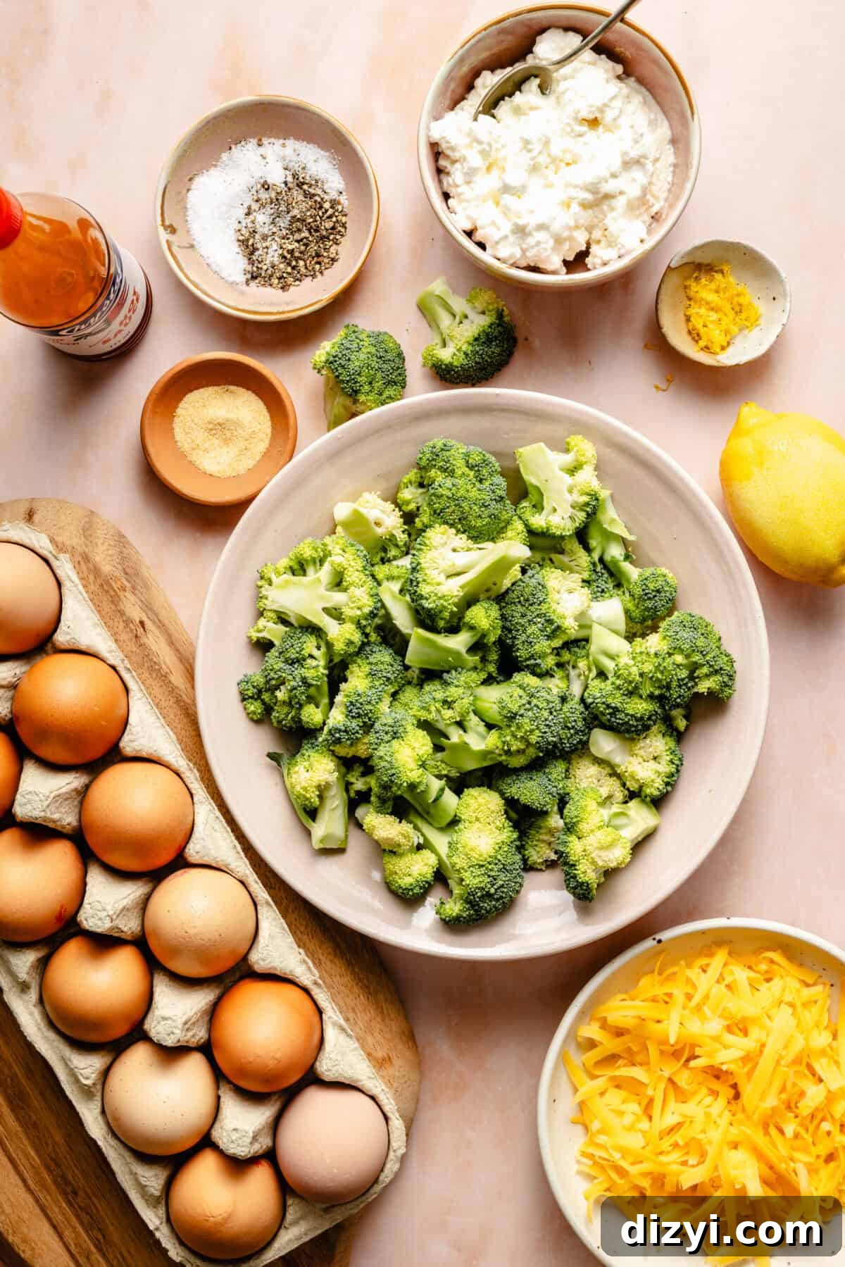 a few bowls containing broccoli florets, shredded cheddar cheese, ricotta cheese, lemon zest, salt, pepper, and eggs