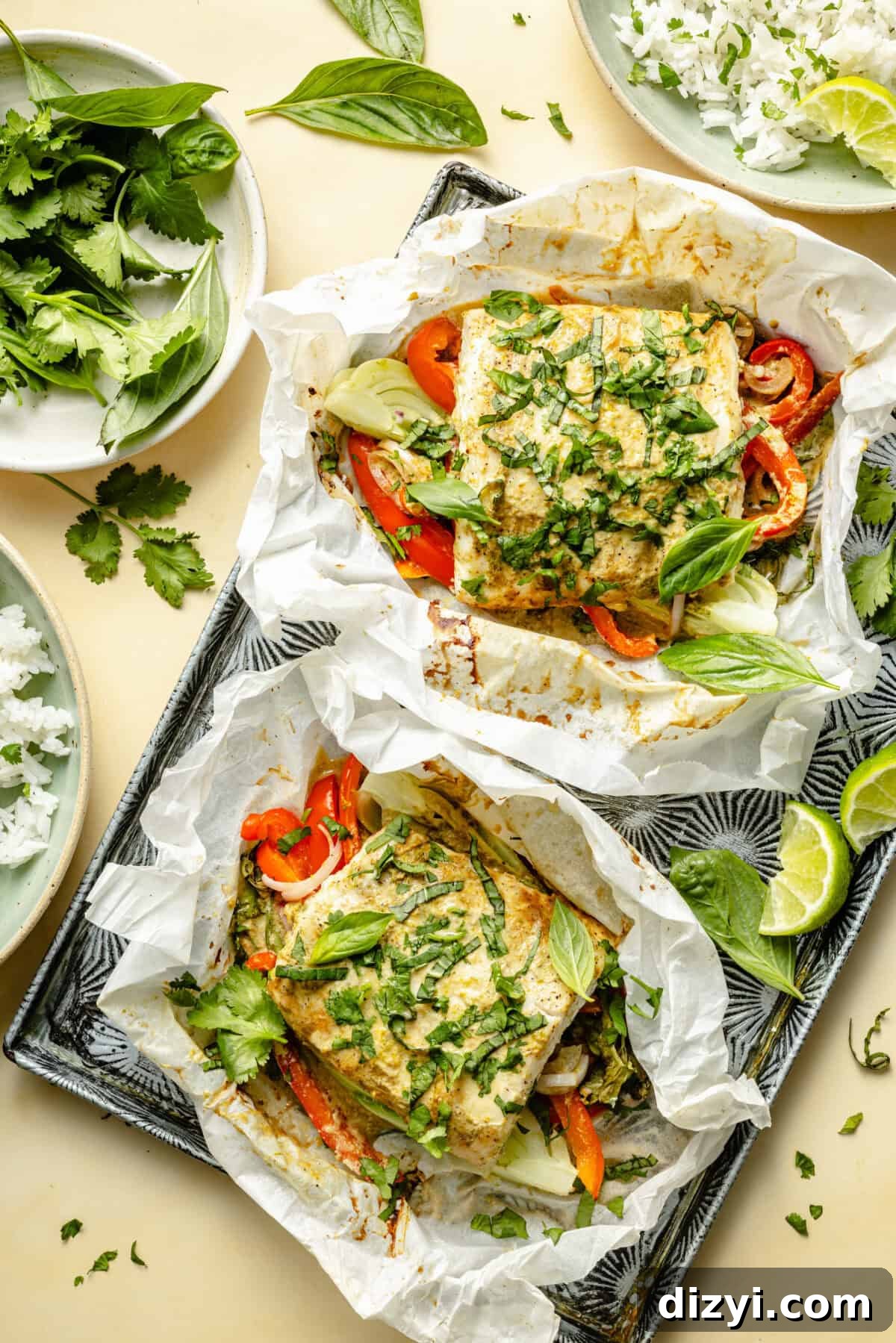 a baking sheet with two filets of fish with vegetables, herbs, and green curry sauce