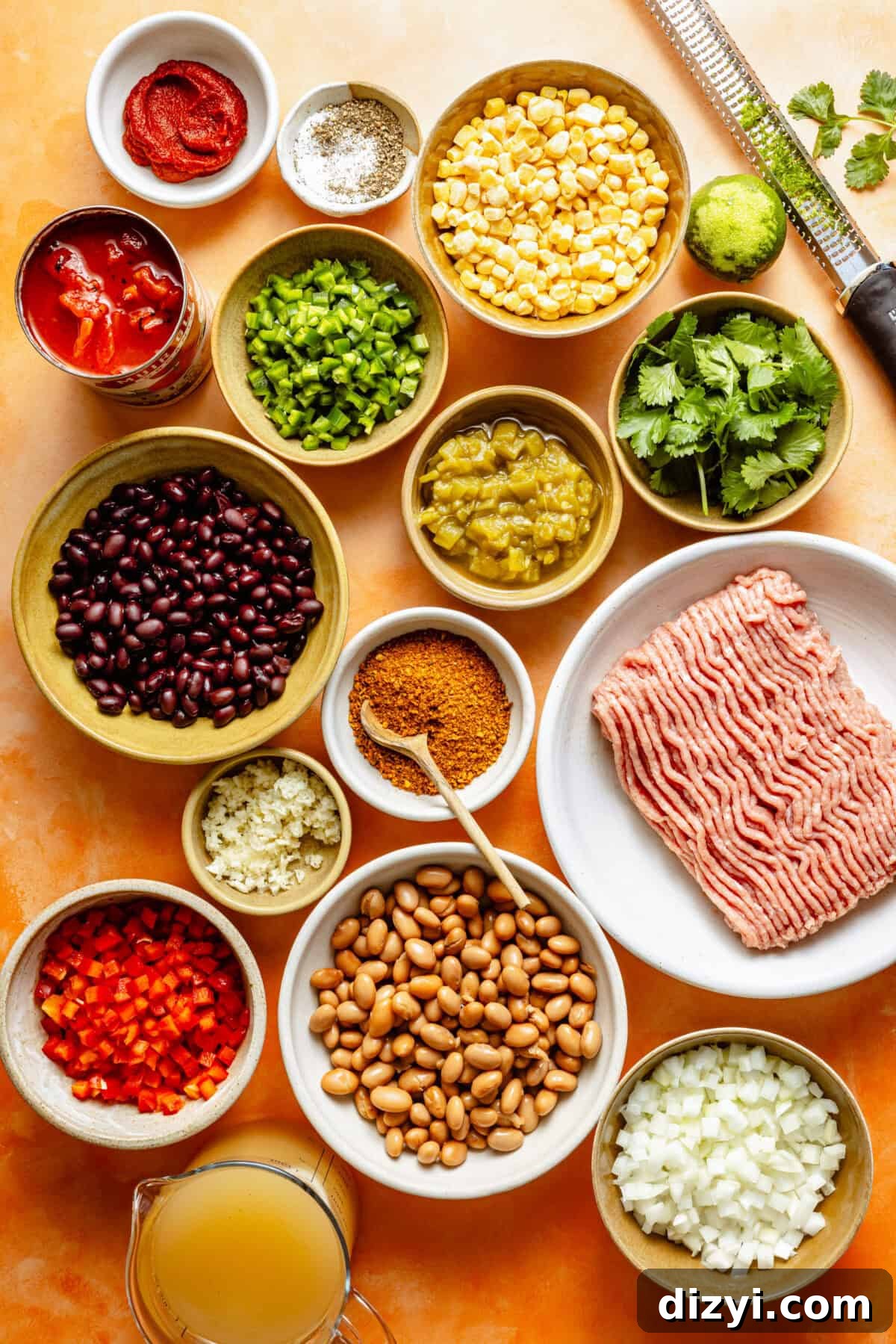 Turkey Taco Soup with Black Beans and Corn 3 a flat-lay of ingredients needed for turkey taco soup including a can of beans, bell peppers, onions, and raw ground turkey