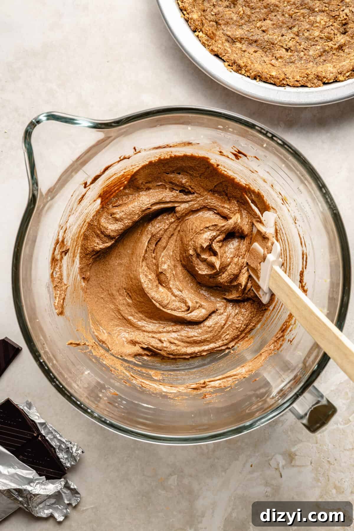 a large glass mixing bowl with a whipped chocolate filling
