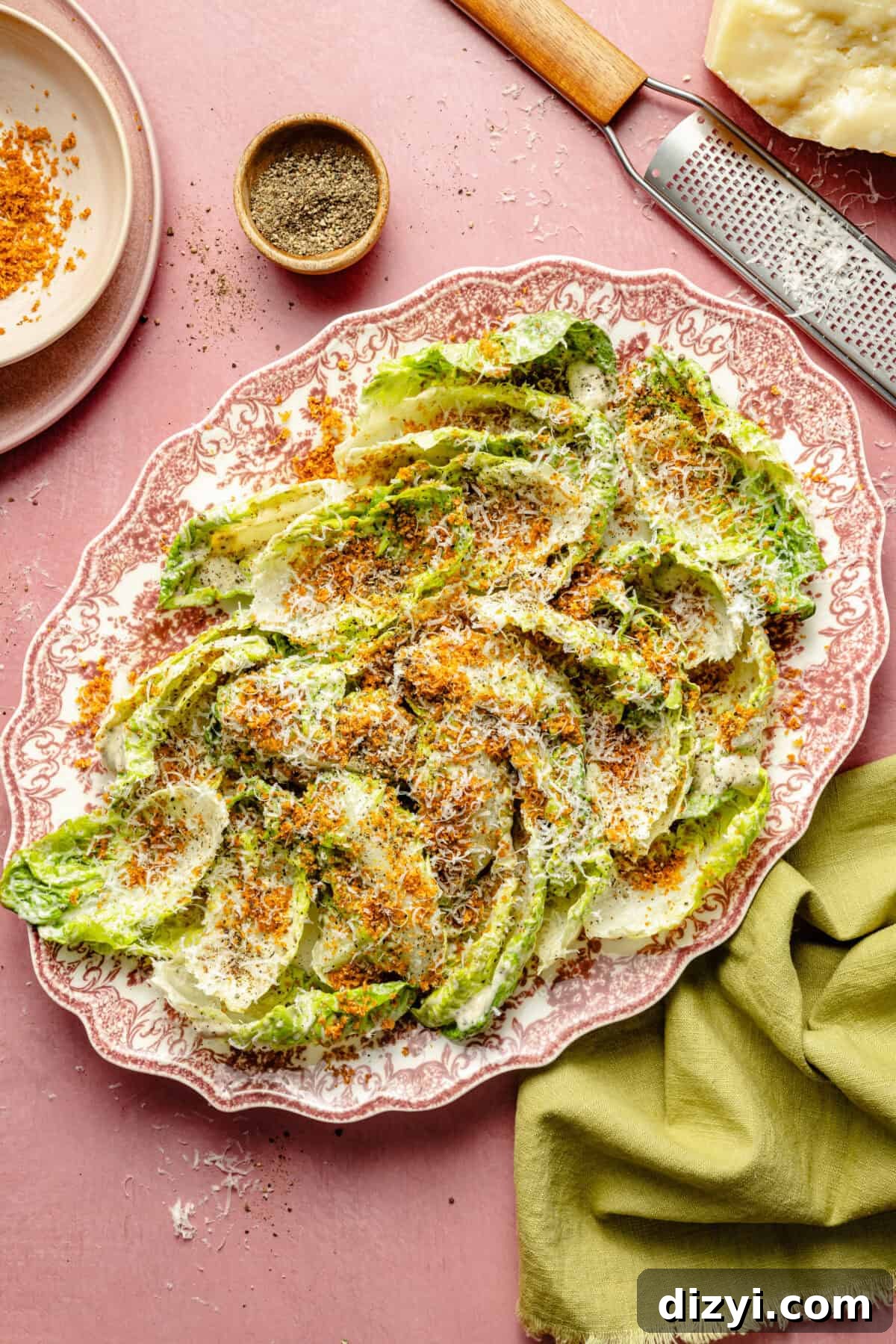 a pink platter with little gem lettuce leaves, dressing, and breadcrumbs