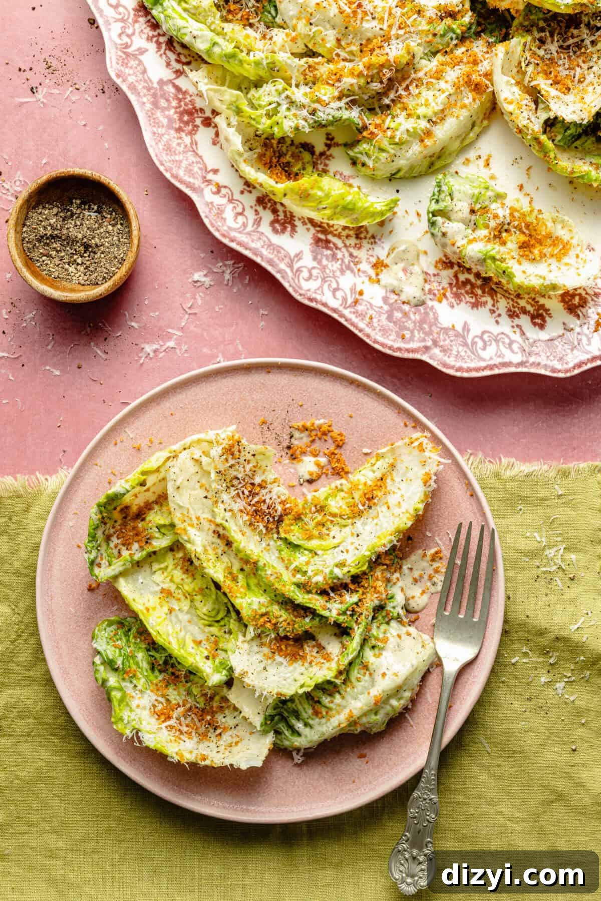 plated salad on a light pink plate with a green napkin