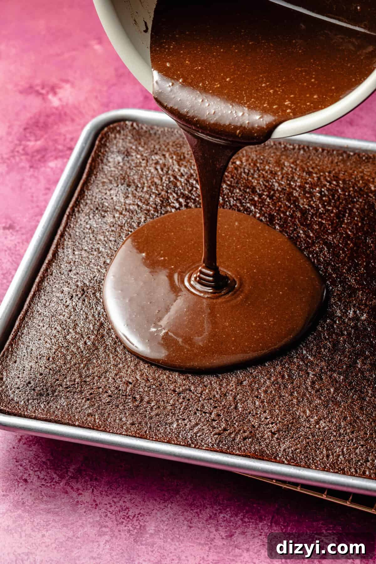 Kiki's Texas Chocolate Sheet Cake Recipe 5 pouring glossy chocolate frosting onto a freshly baked chocolate sheet cake