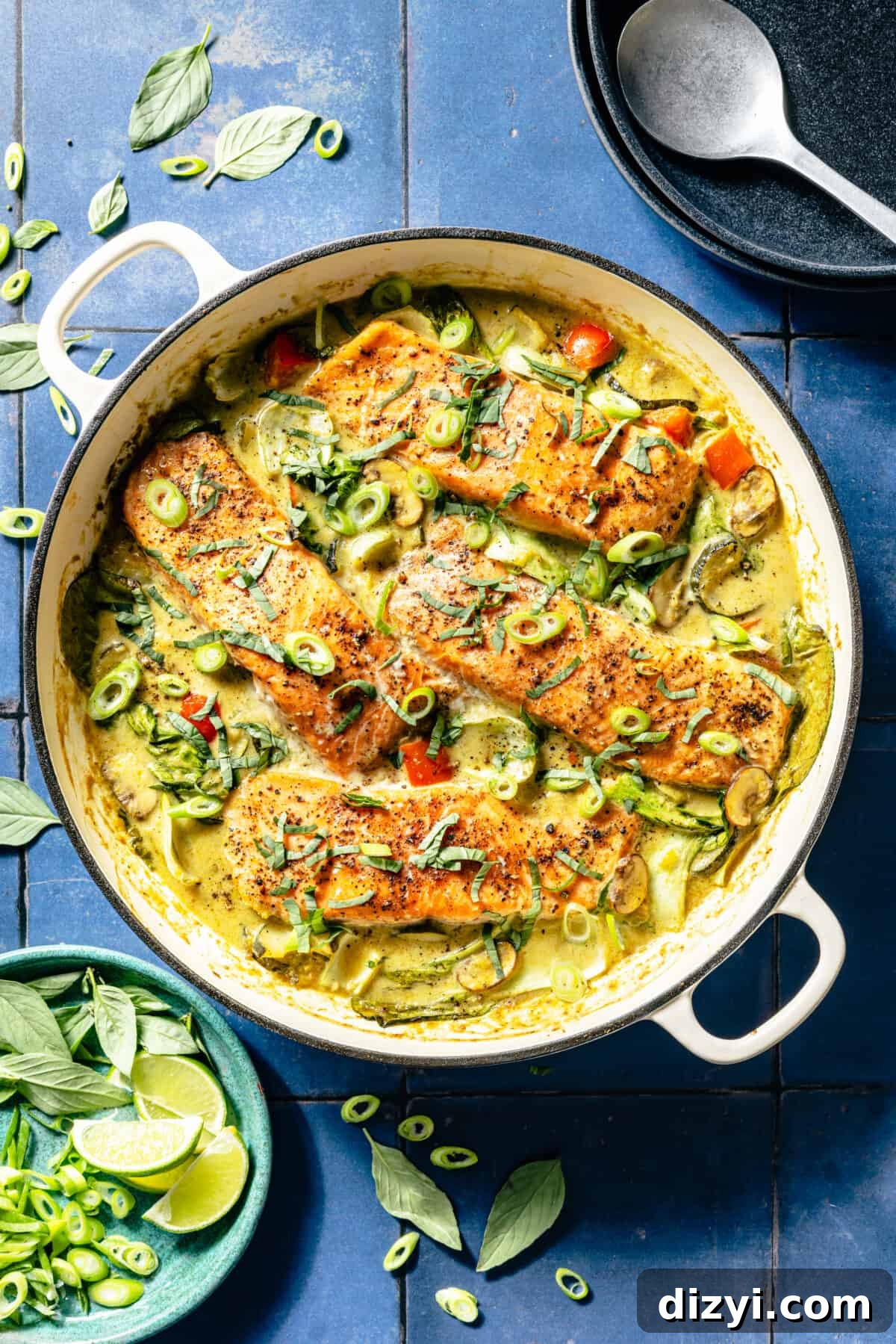 Thai Coconut Green Curry Salmon Recipe 2 Thai-Inspired Coconut Green Curry Salmon in white skillet on blue tile background.