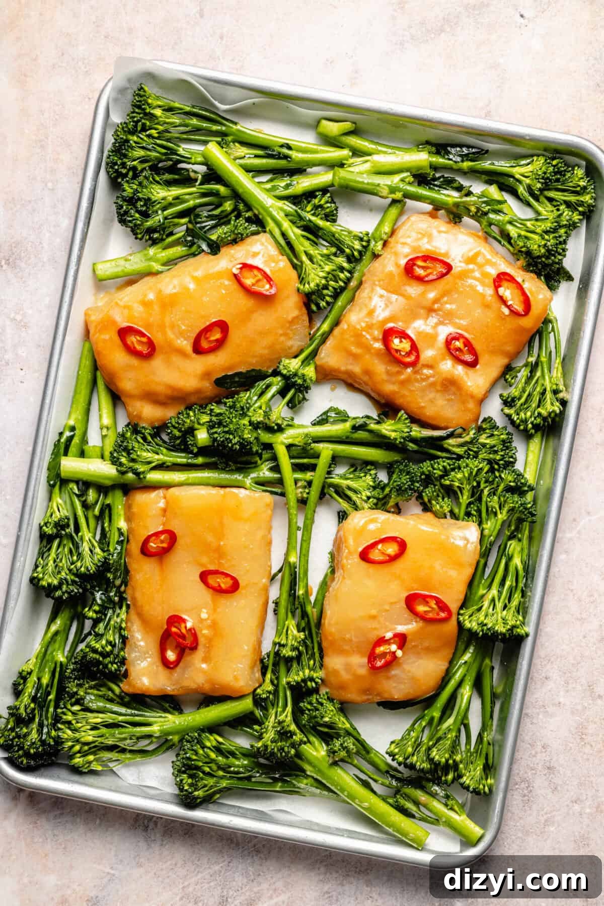 an aluminum sheet tray with miso-marinated cod, spicy peppers, and broccolini
