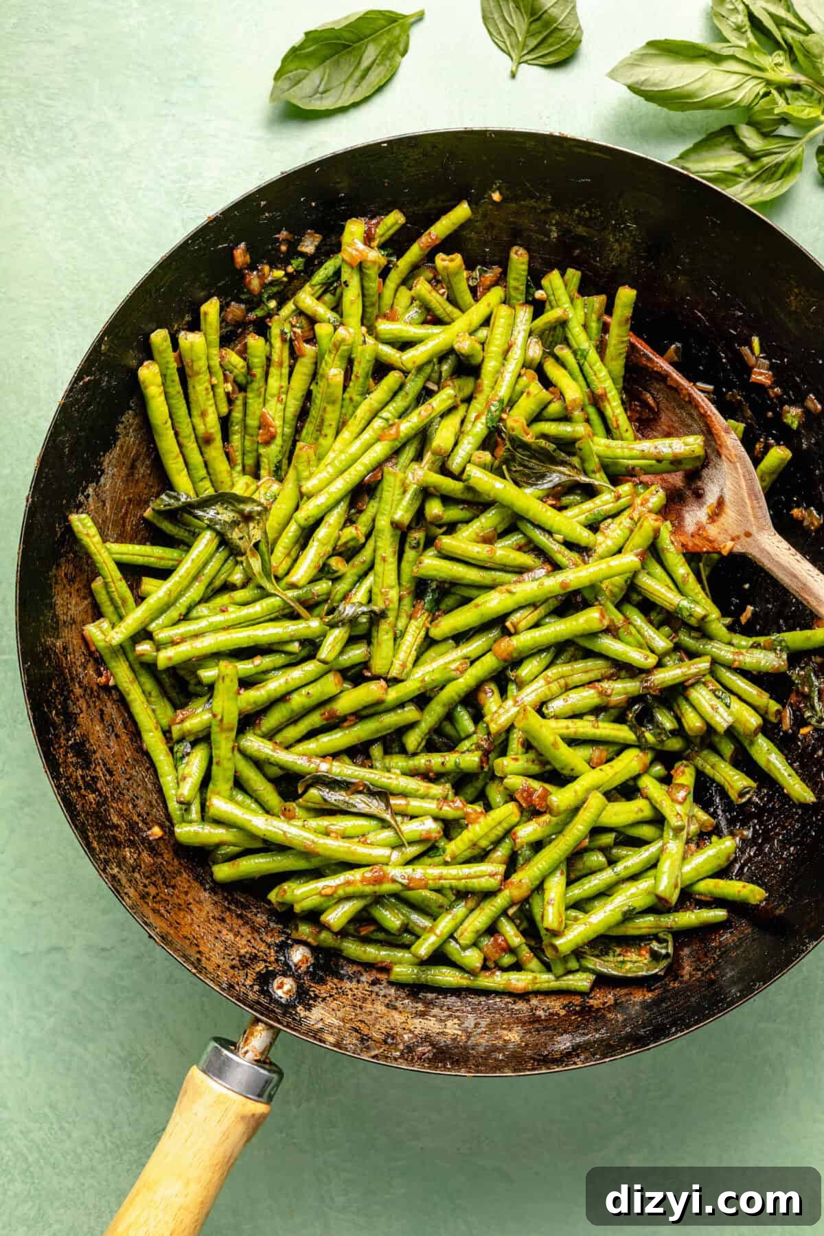 Prik King Stir-Fry: Thai Dry Red Curry 4 a carbon steel wok with green beans on a high green background