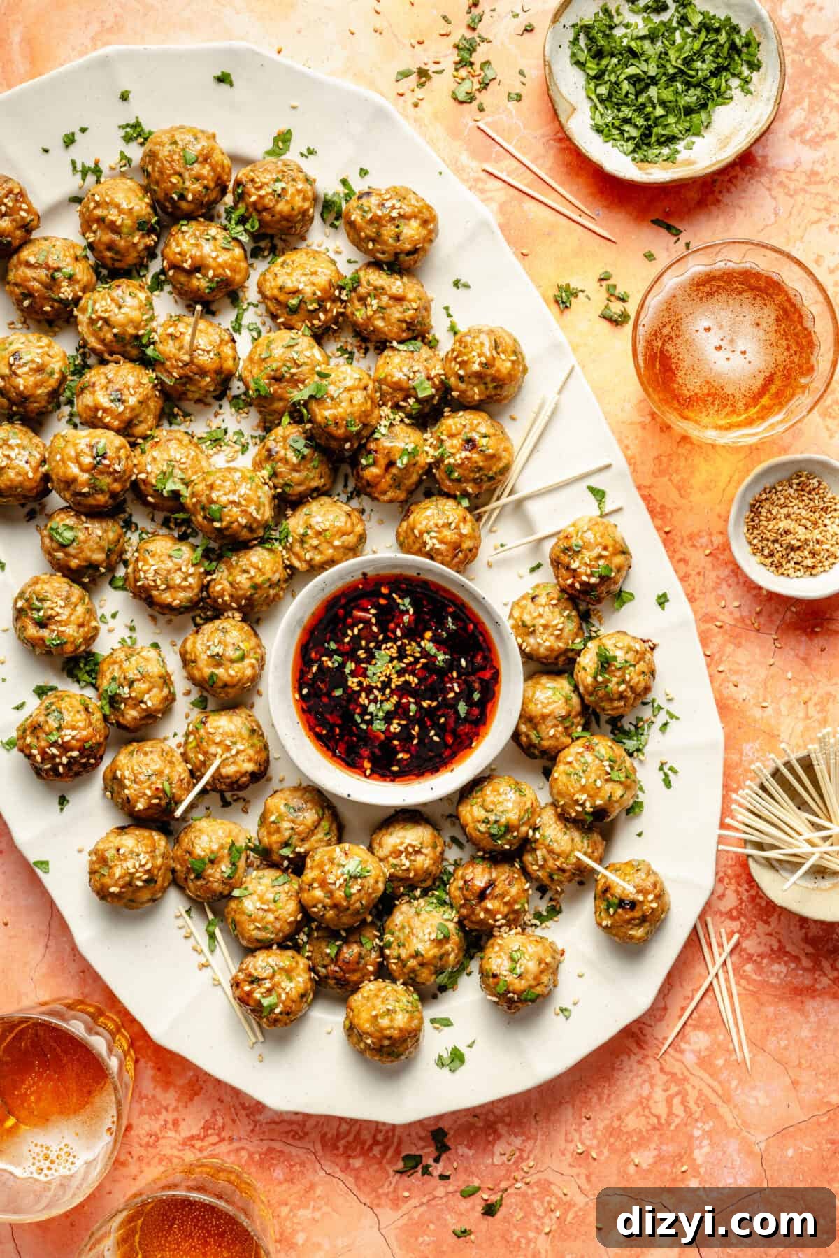 Chicken-Scallion Dumpling Meatballs with Chili-Sesame Drizzle 2 a white platter with chicken and scallion meatballs on toothpicks and a chili dipping sauce