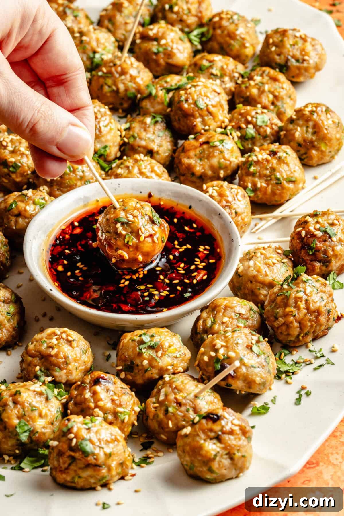 Chicken-Scallion Dumpling Meatballs with Chili-Sesame Drizzle 5 a platter of chicken and scallion meatballs dipped in a chili-sesame sauce