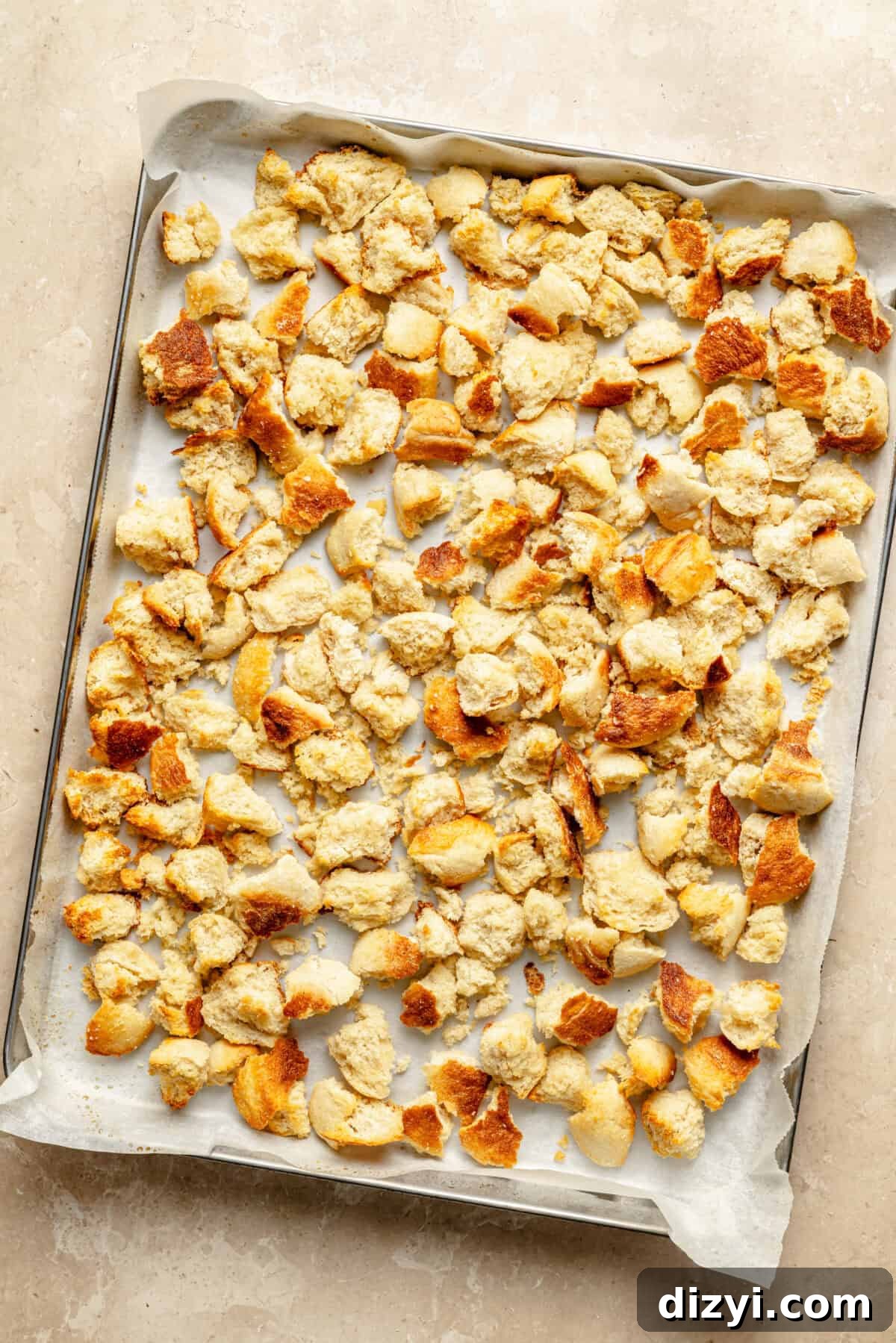 torn english muffins on a sheet tray lined with parchment 