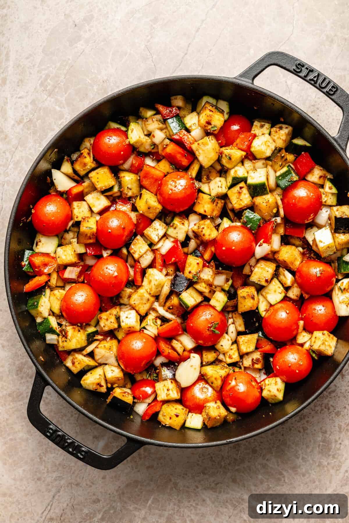 a large cast-iron skillet with sautéed vegetables and tomatoes