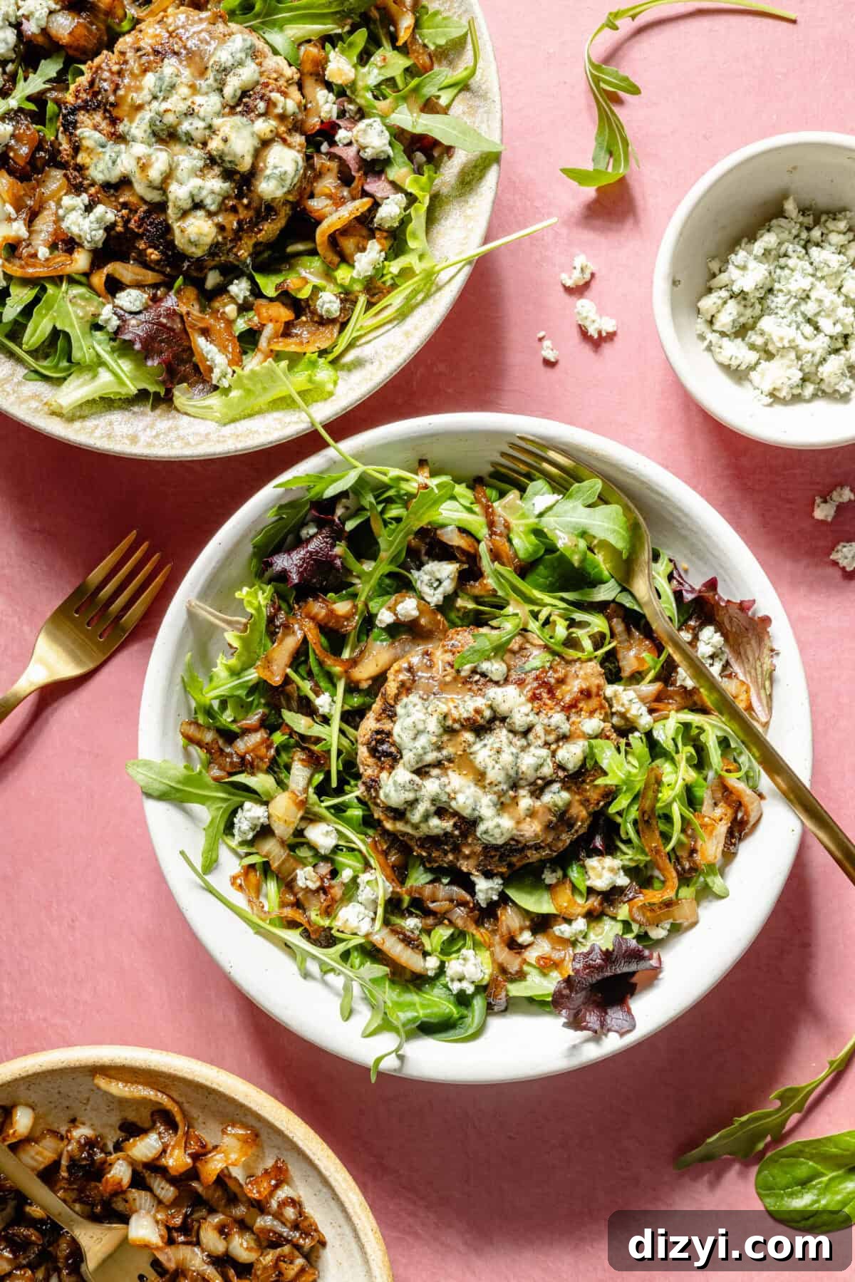 Blue Cheese Burger Salad with Balsamic Vinaigrette 2 Two large white bowls with salad greens, caramelized onions, and blue cheese-topped burgers