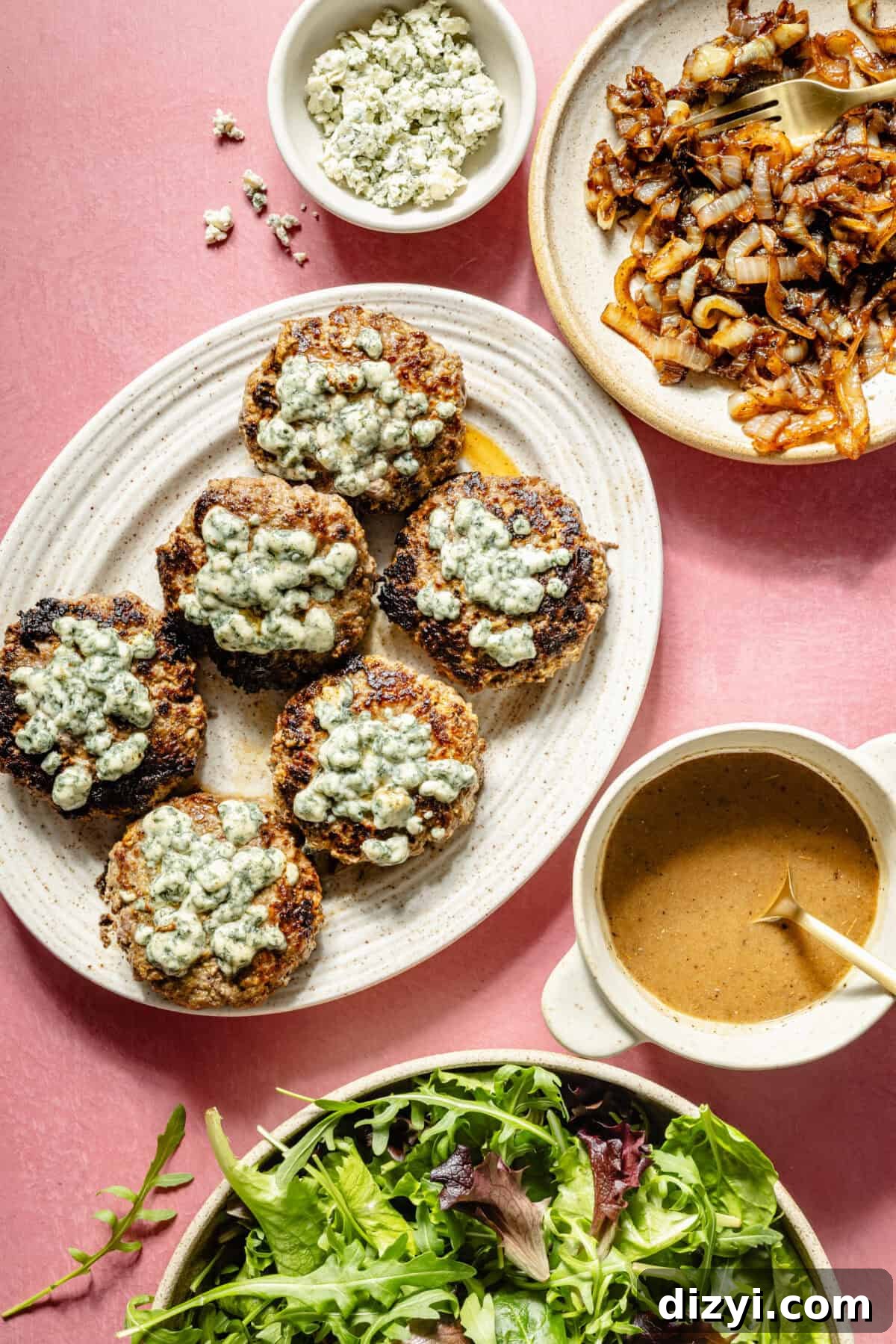 Blue Cheese Burger Salad with Balsamic Vinaigrette 6 A white platter with blue cheese-topped burgers and a side plate of caramelized onions
