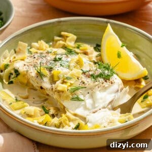 an up-close photo of halibut, leeks, fresh herbs, and lemon wedges in a low bowl