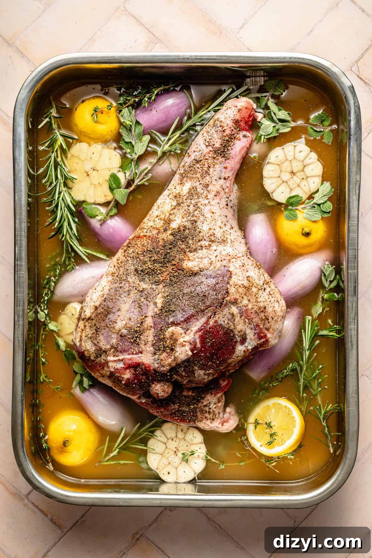 bone-in leg of lamb in a roasting pan with wine, broth, and aromatics