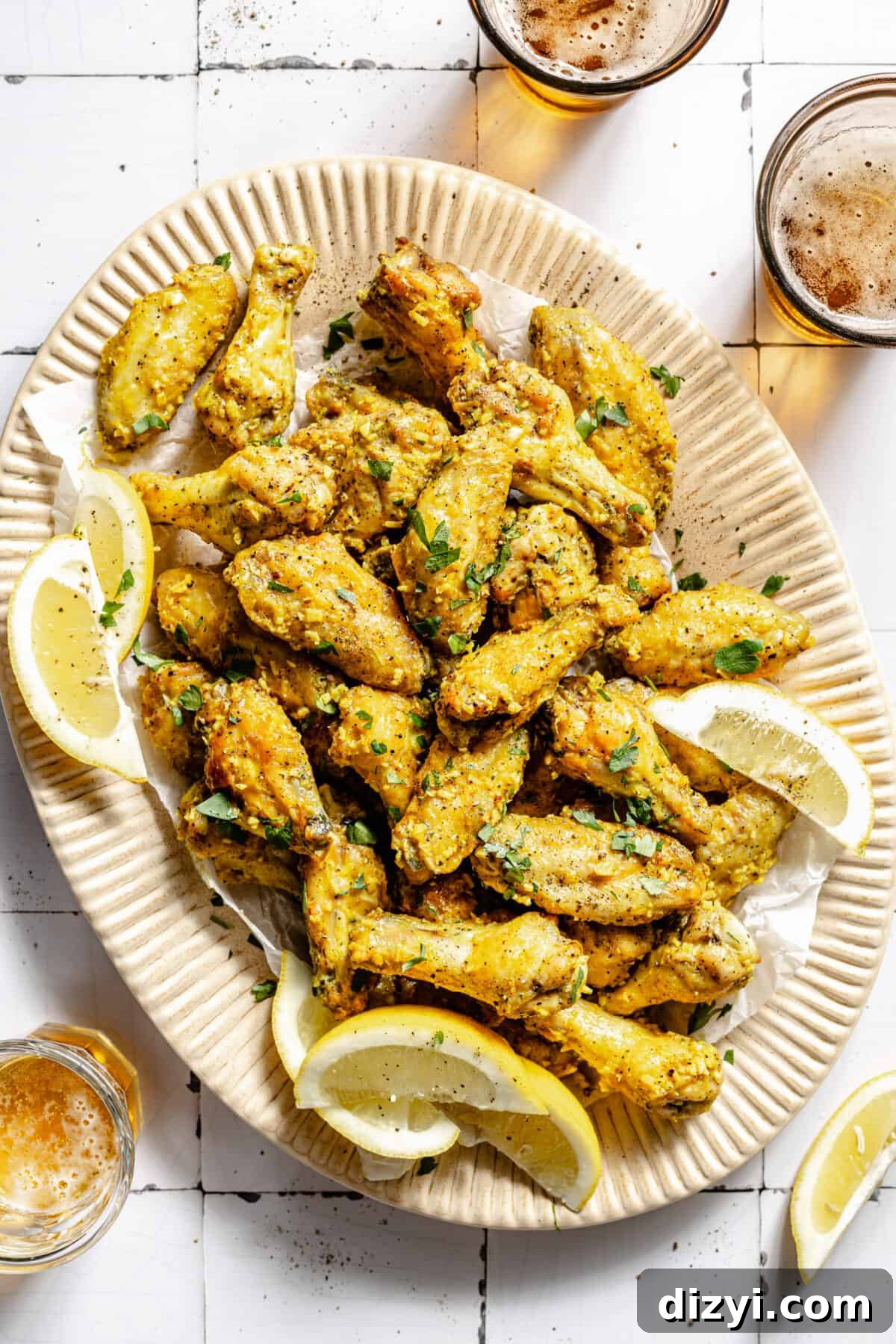 Lemon Pepper Baked Chicken Wings on platter. Lemon wedges on platter.
