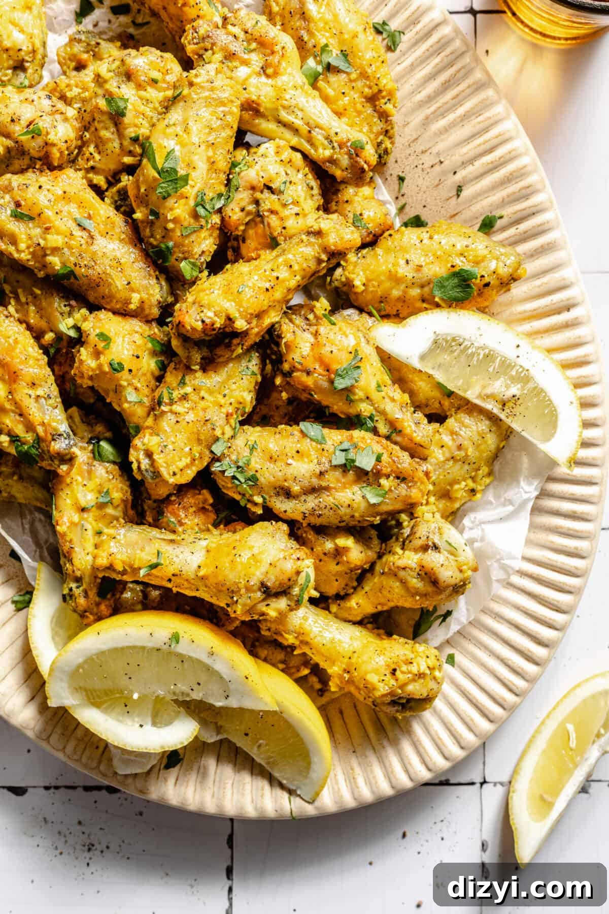 Lemon Pepper Baked Chicken Wings on platter with lemon wedges.