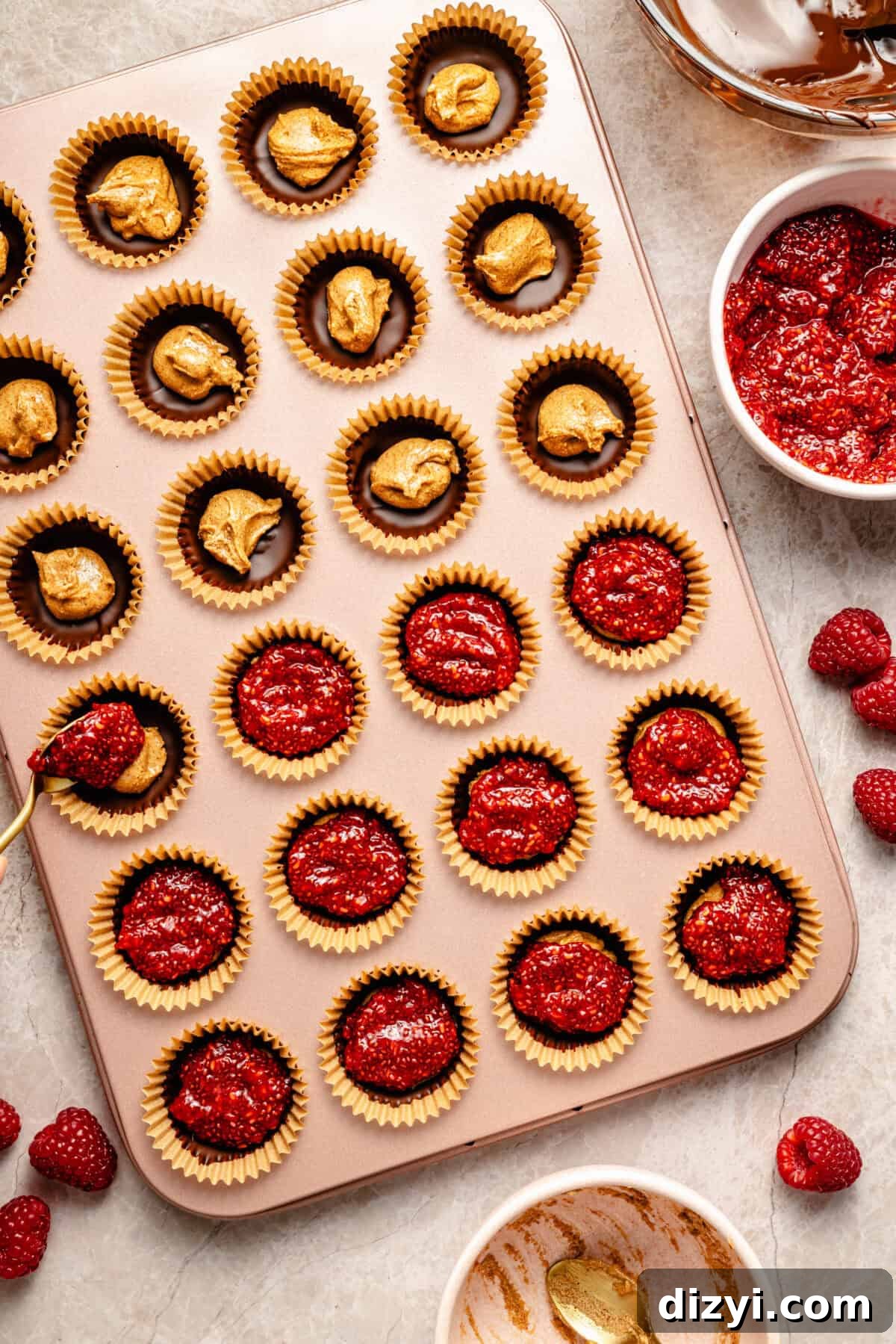 homemade almond butter and raspberry cups in a metal mini muffin tin