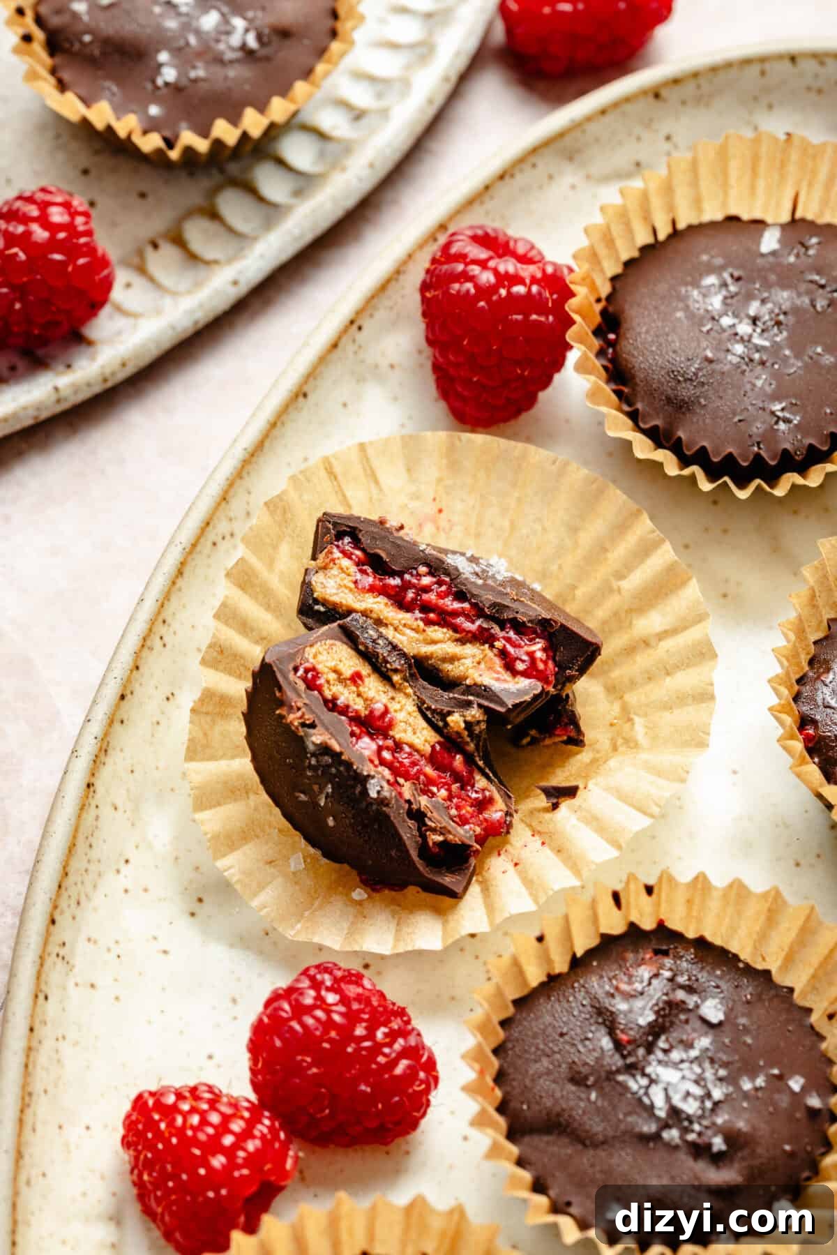 a cut almond butter and raspberry cup encased in chocolate