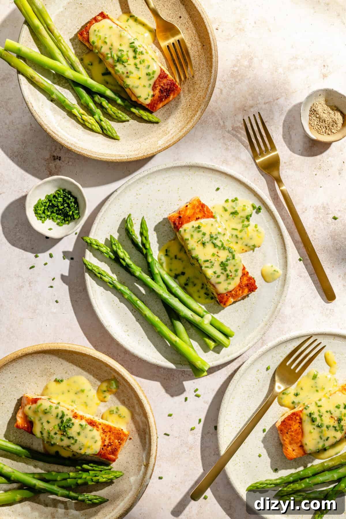 Pan Seared Salmon with Lemon Chive Beurre Blanc Recipe 2 four plates with seared salmon dressed with a lemon chive butter sauce and fresh asparagus