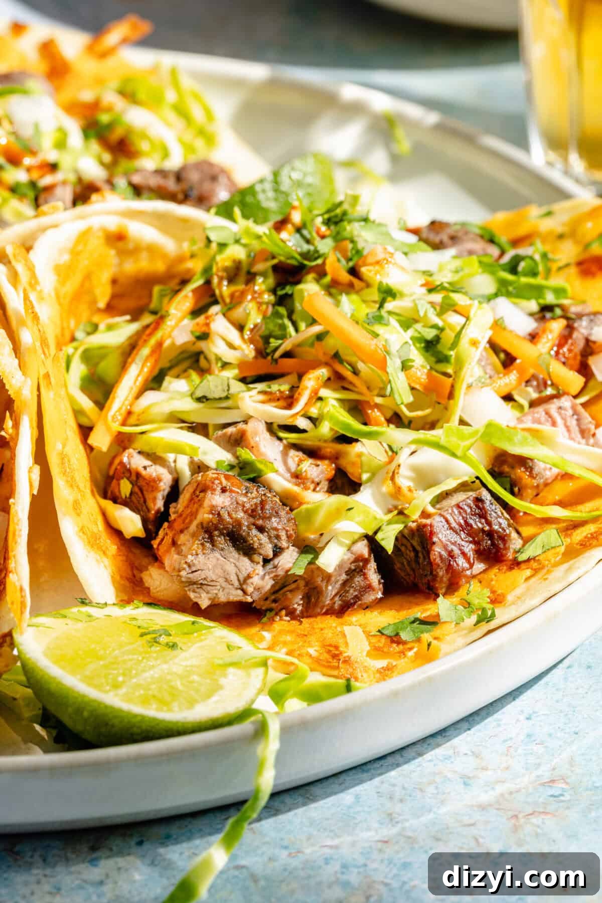 a close-up of grilled ribeye tacos with cabbage slaw and cheese-crusted tortillas