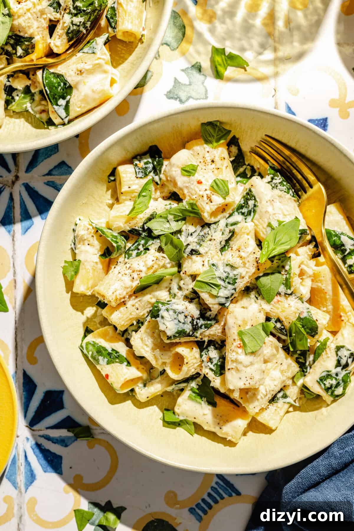 Creamy Lemon Pasta with Ricotta and Basil in a bowl on a tiled surface.