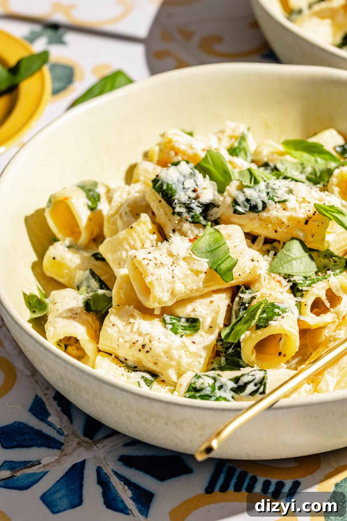 Creamy Lemon Pasta with Ricotta and Basil in shallow bowl on tiled surface.
