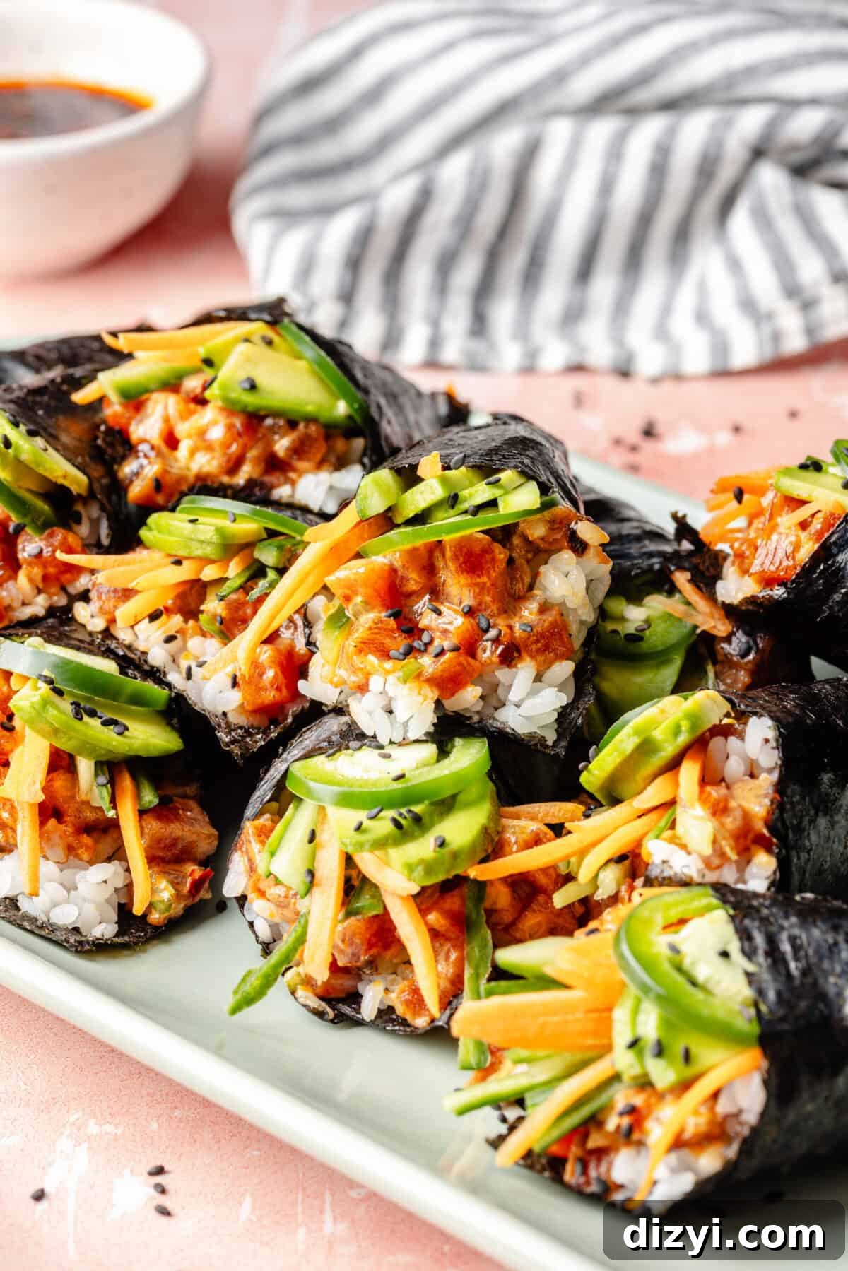 How to Make Spicy Tuna Hand Rolls 3 Spicy Tuna Hand rolls on a tray.