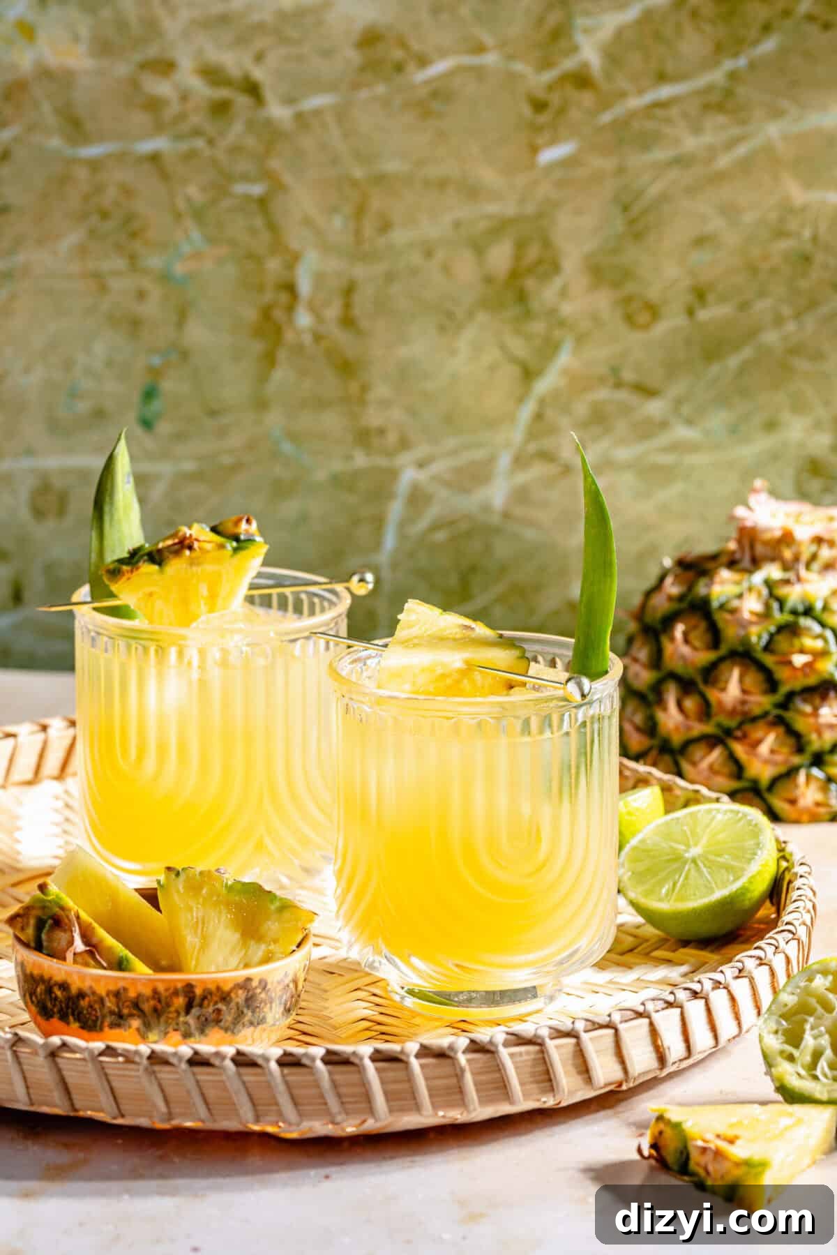 Kauai Margarita: Smoky Pineapple Cocktail Recipe 2 The Kauai Margarita IN TWO GLASSES ON WOVEN TRAY WITH GREEN BACKDROP