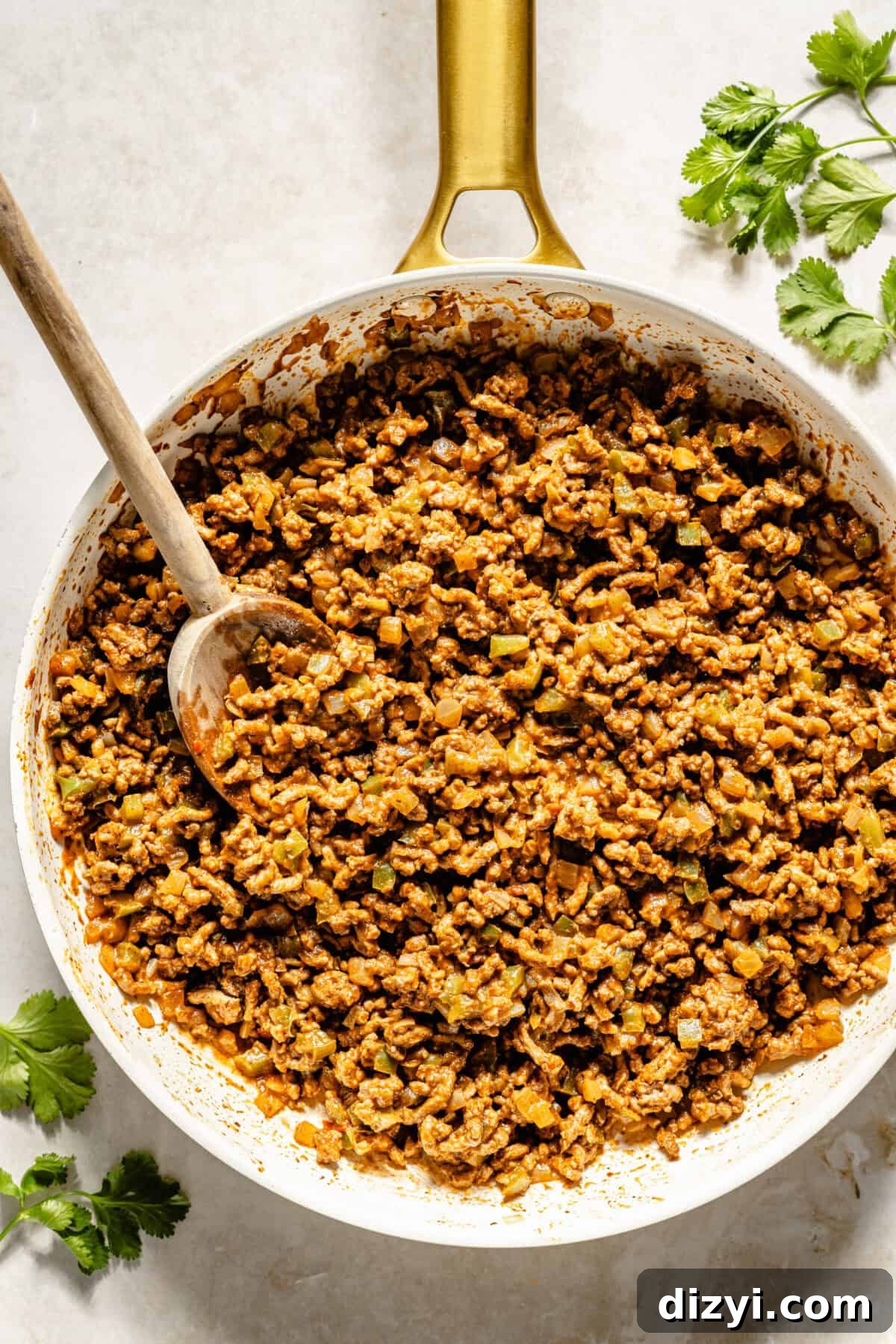 Sloppy Janes: Homemade Sloppy Joe‑Style Sandwiches 3 A white pan of meat with sauce. The pan has a gold handle. There is a wooden spoon in the pan, and sprigs of cilantro around the pan.