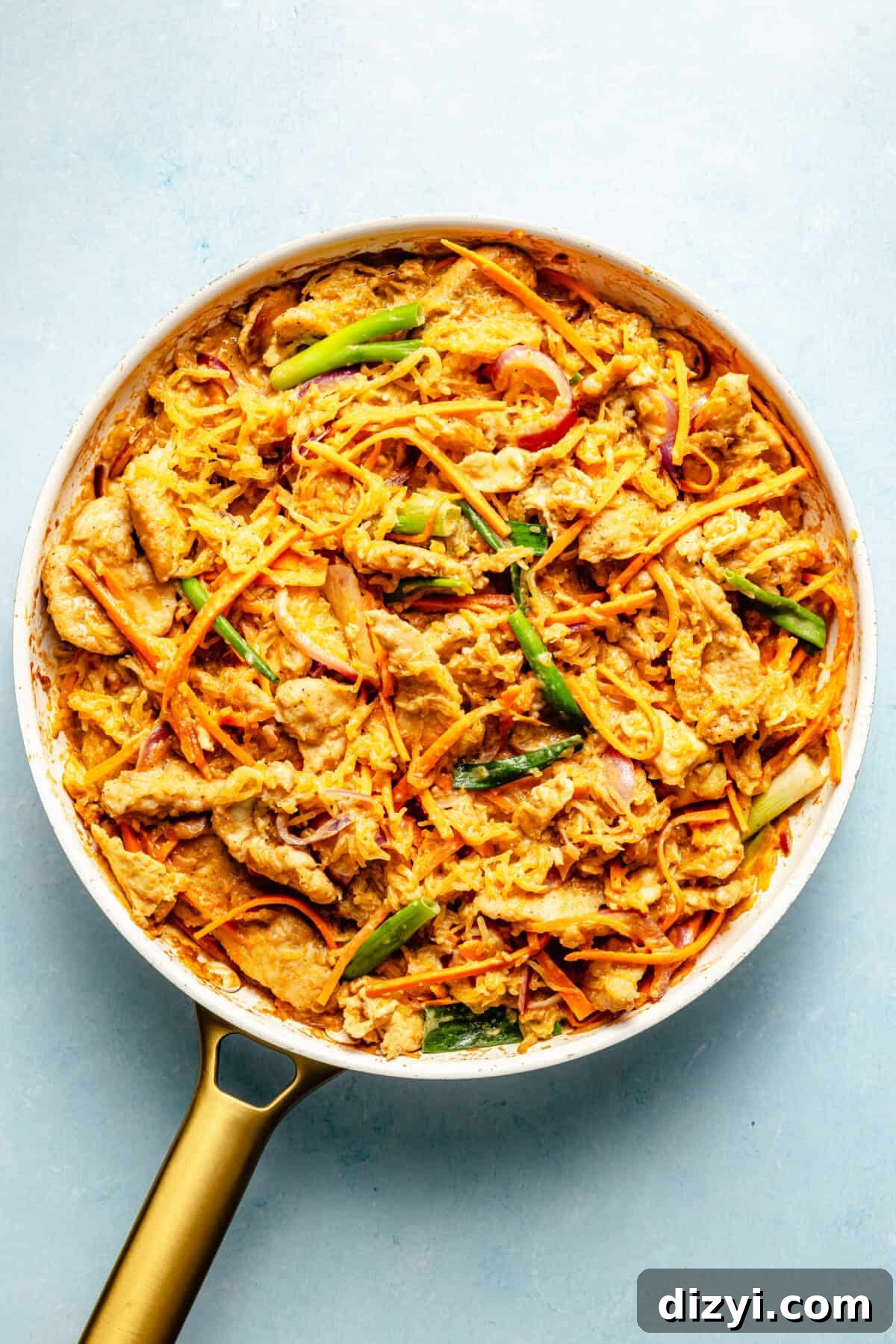 Whole30 Spaghetti Squash Pad Thai Recipe 4 a white skillet on a blue background filled with spaghetti squash pad thai