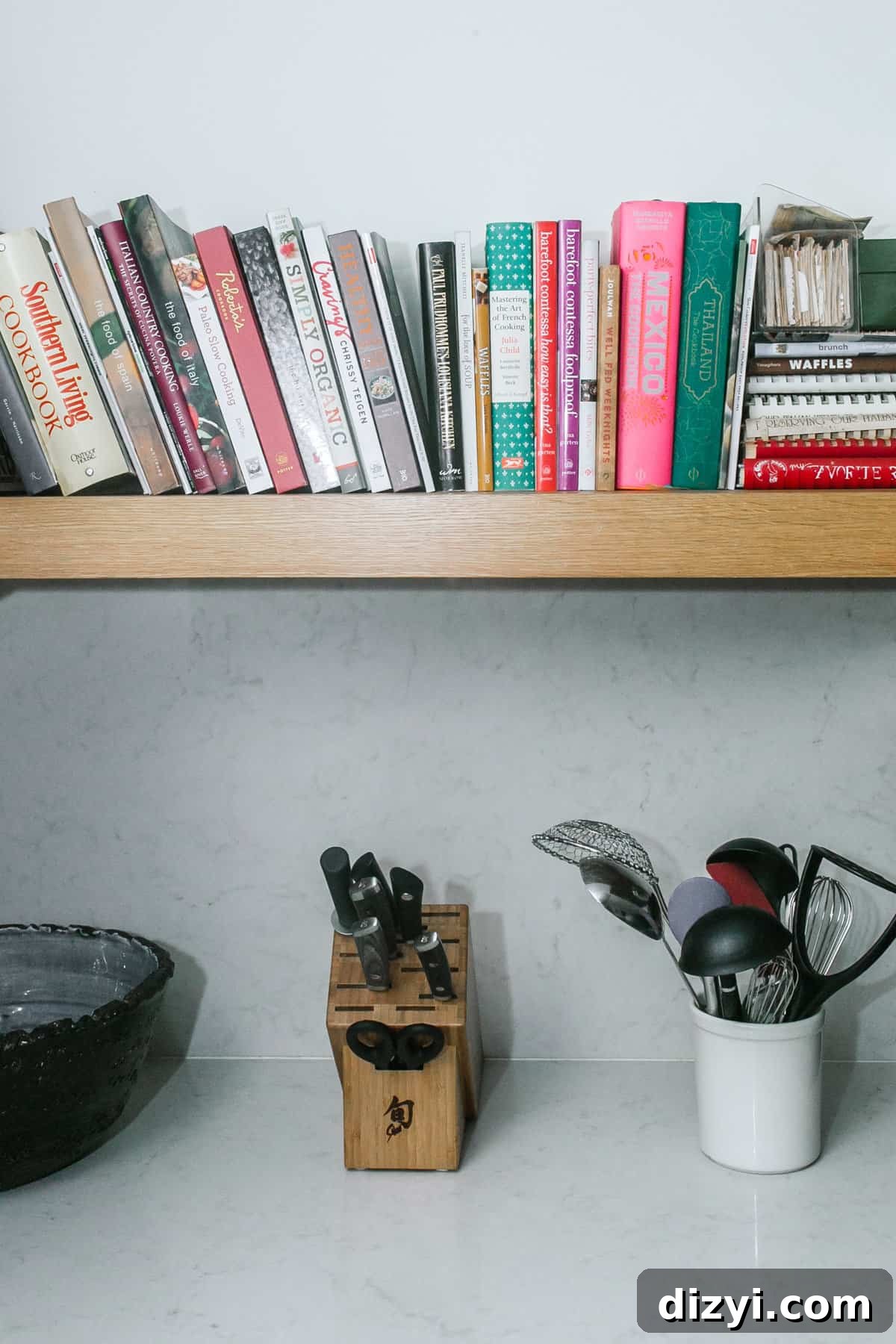 Stack of favorite cookbooks on open shelving