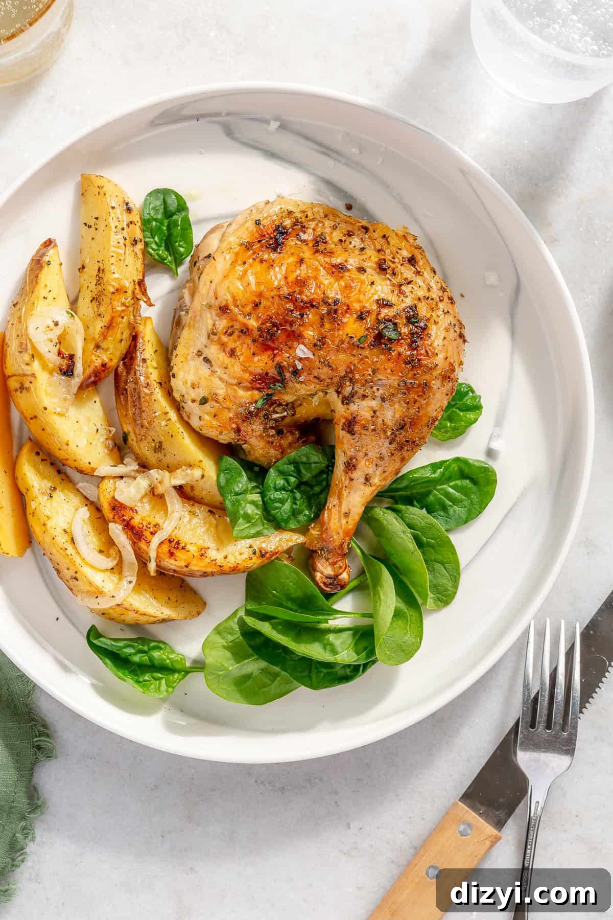 Whole Greek Roast Chicken with Lemon Potatoes 8 Whole Roasted Greek Chicken leg on plate with Potatoes and spinach.