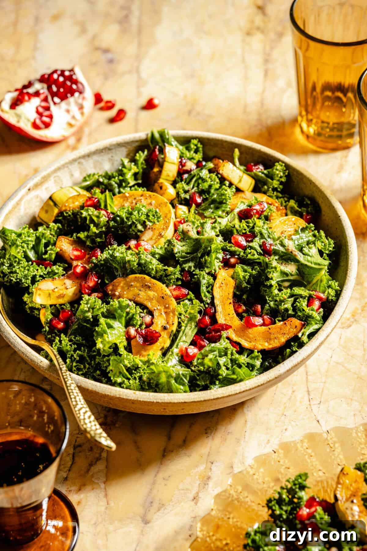 A finished bowl of Kale Salad with Roasted Delicata Squash and Miso Dressing with a serving spoon.
