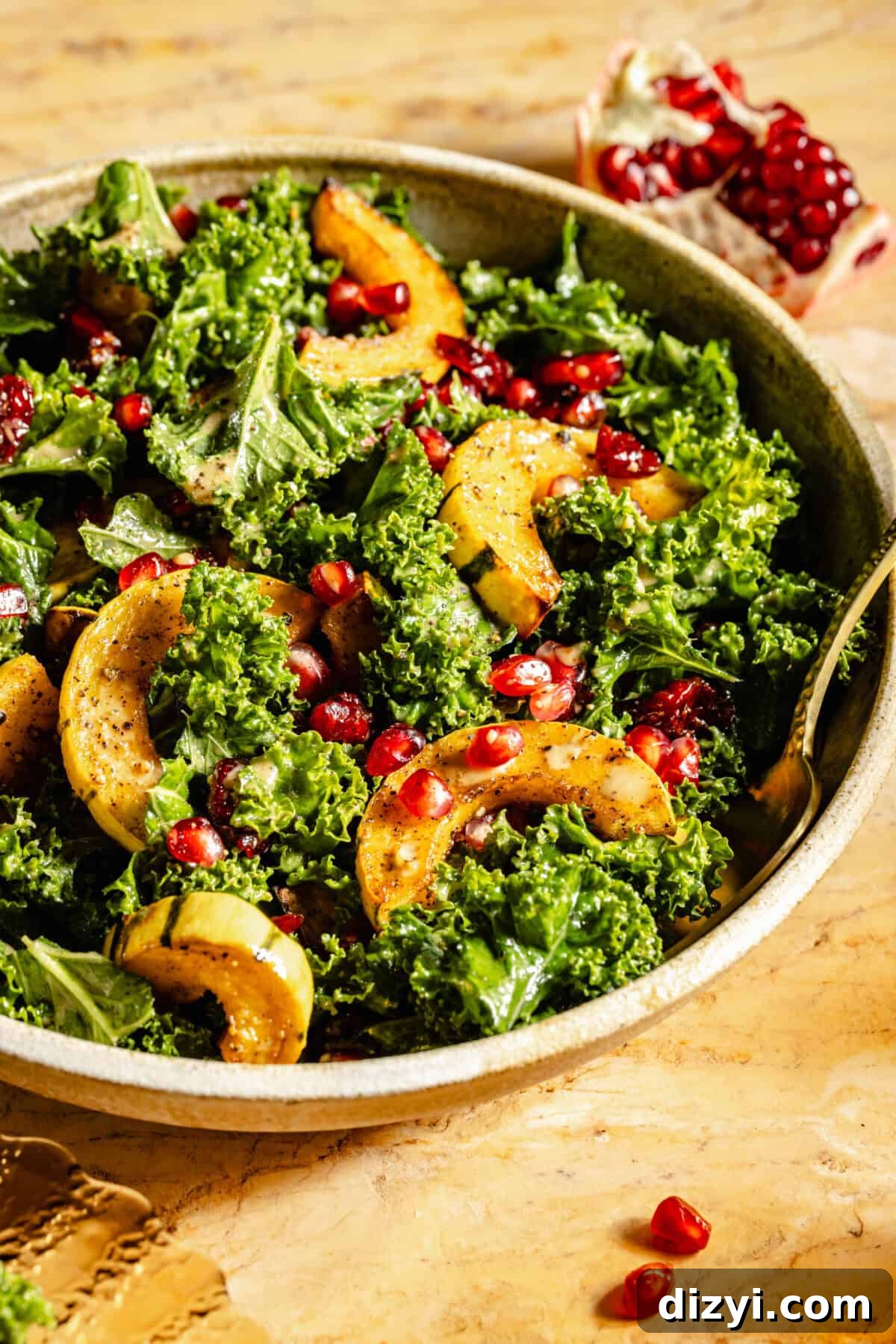 A close up shot of a finished serving dish of Kale Salad with Roasted Delicata Squash and Miso Dressing