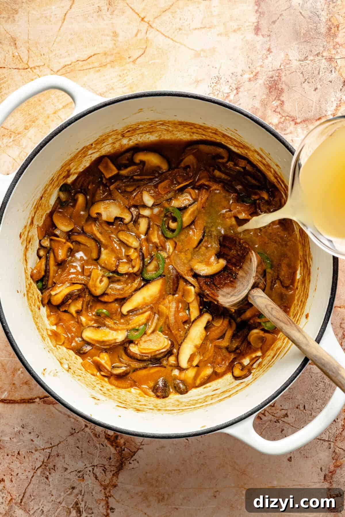 a large white pot with sautéed mushrooms, jalapeño peppers, and chicken broth