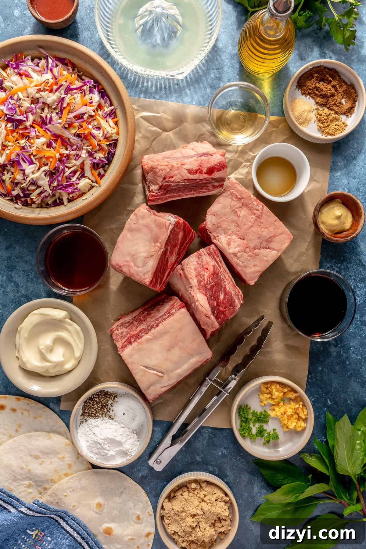 The ingredients needed to make Five Spice Short Rib Tacos in various bowls and dishes laid out on a blue countertop.