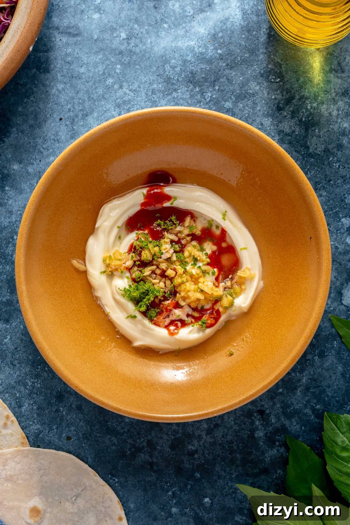 A small yellow bowl with the ingredients for the Sriracha Aioli ready to be mixed.
