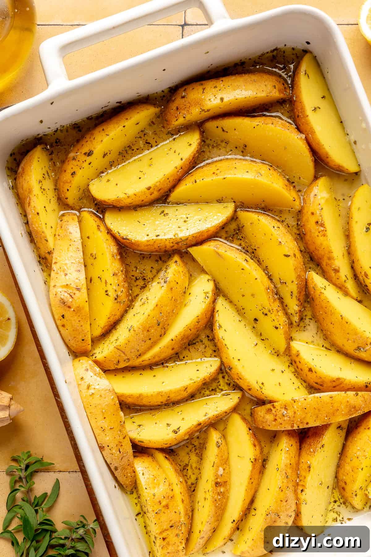 Potato wedges in white baking dish with all other ingredients mixed in.