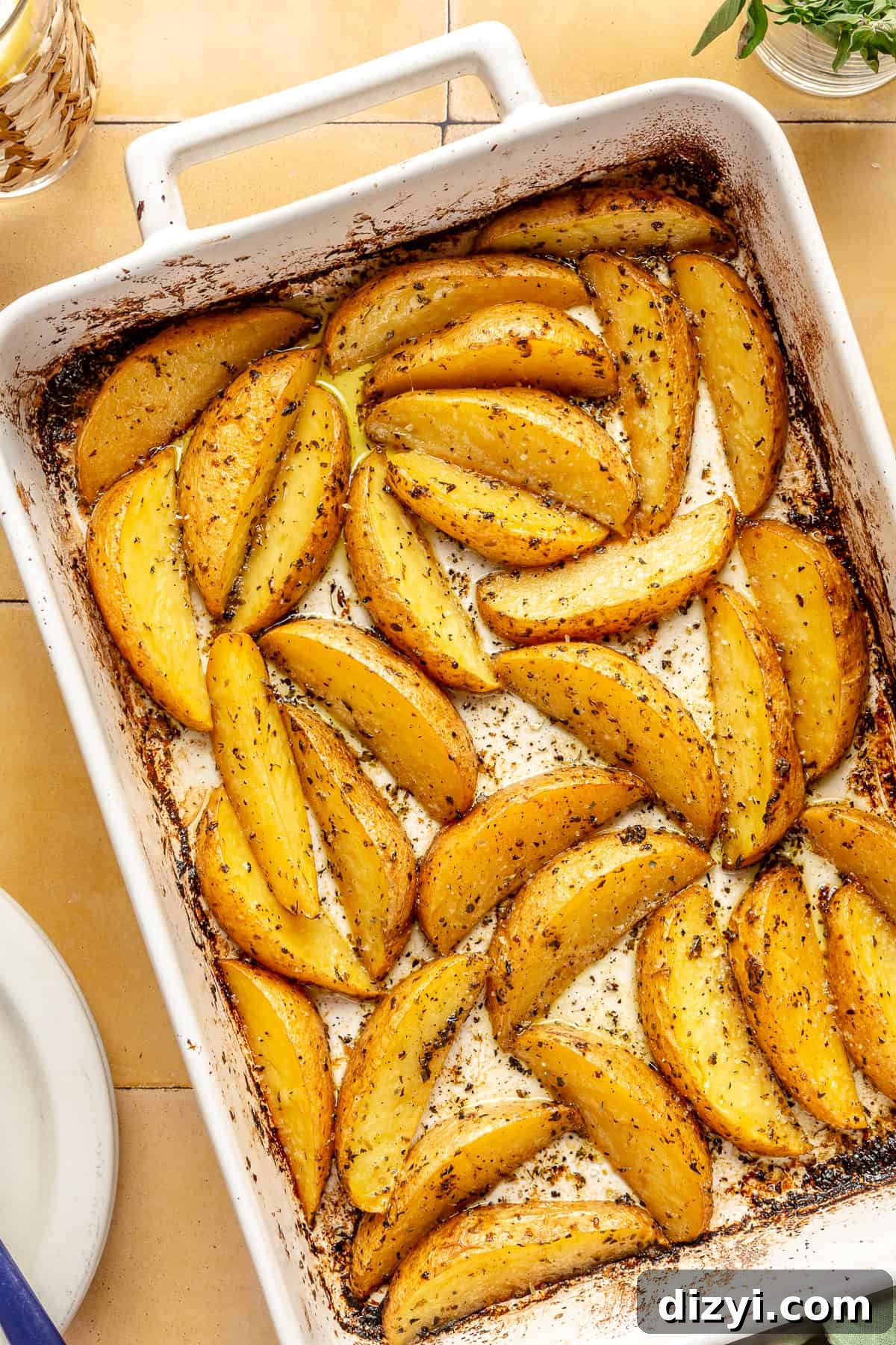 Greek-Style Potatoes baked until slightly browned in white baking dish.