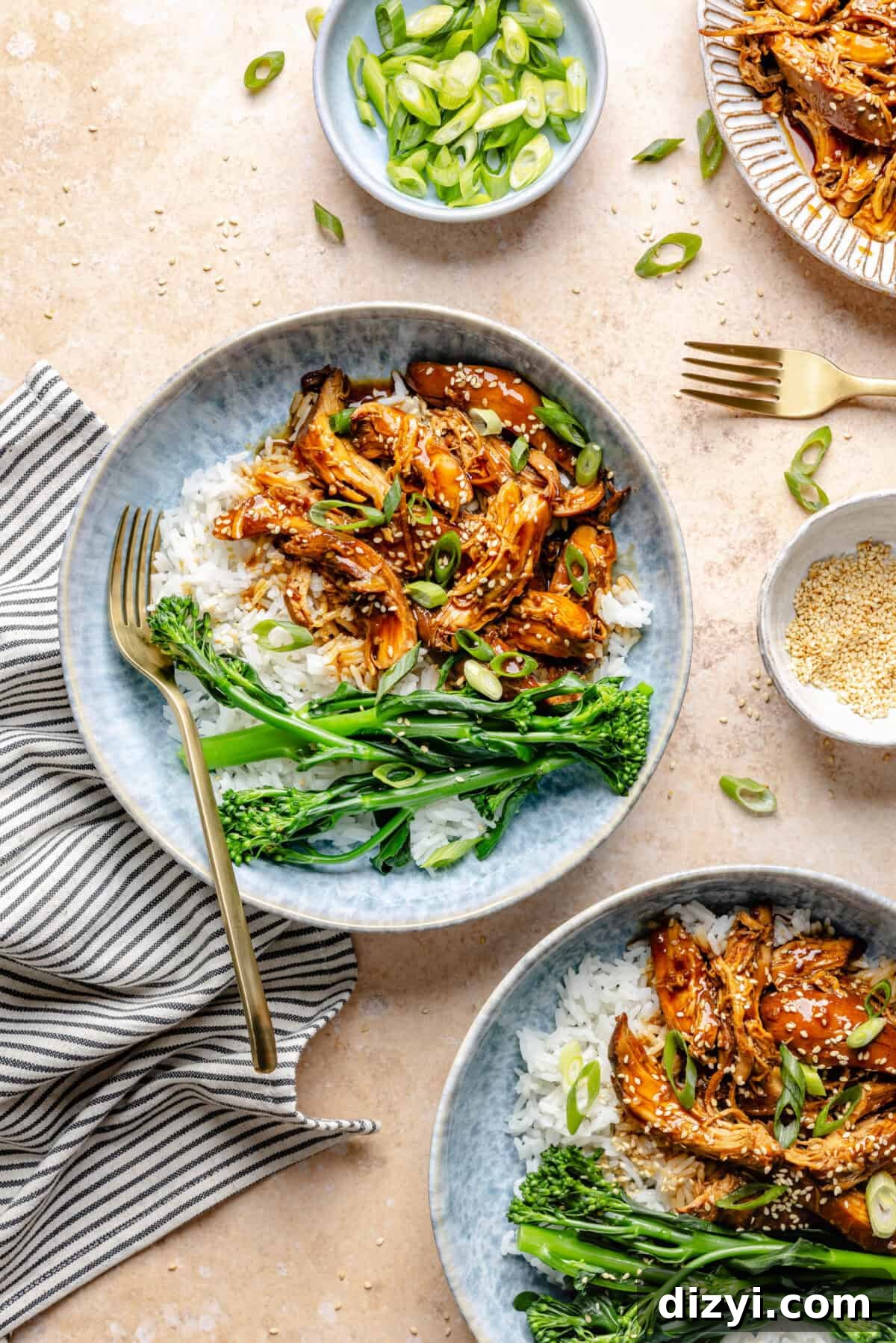 Slow Cooker Honey-Sesame Chicken in two bowls served over rice with side of green beans.