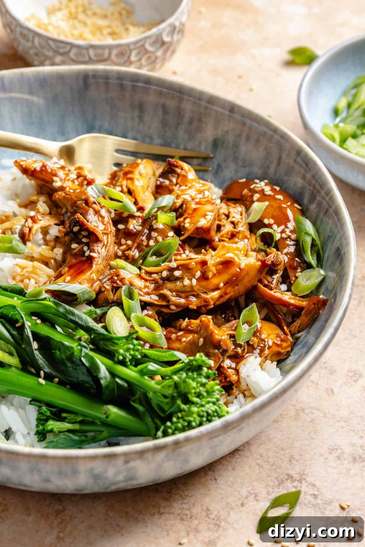 Slow Cooker Honey-Sesame Chicken in bowl served over rice with green beans.