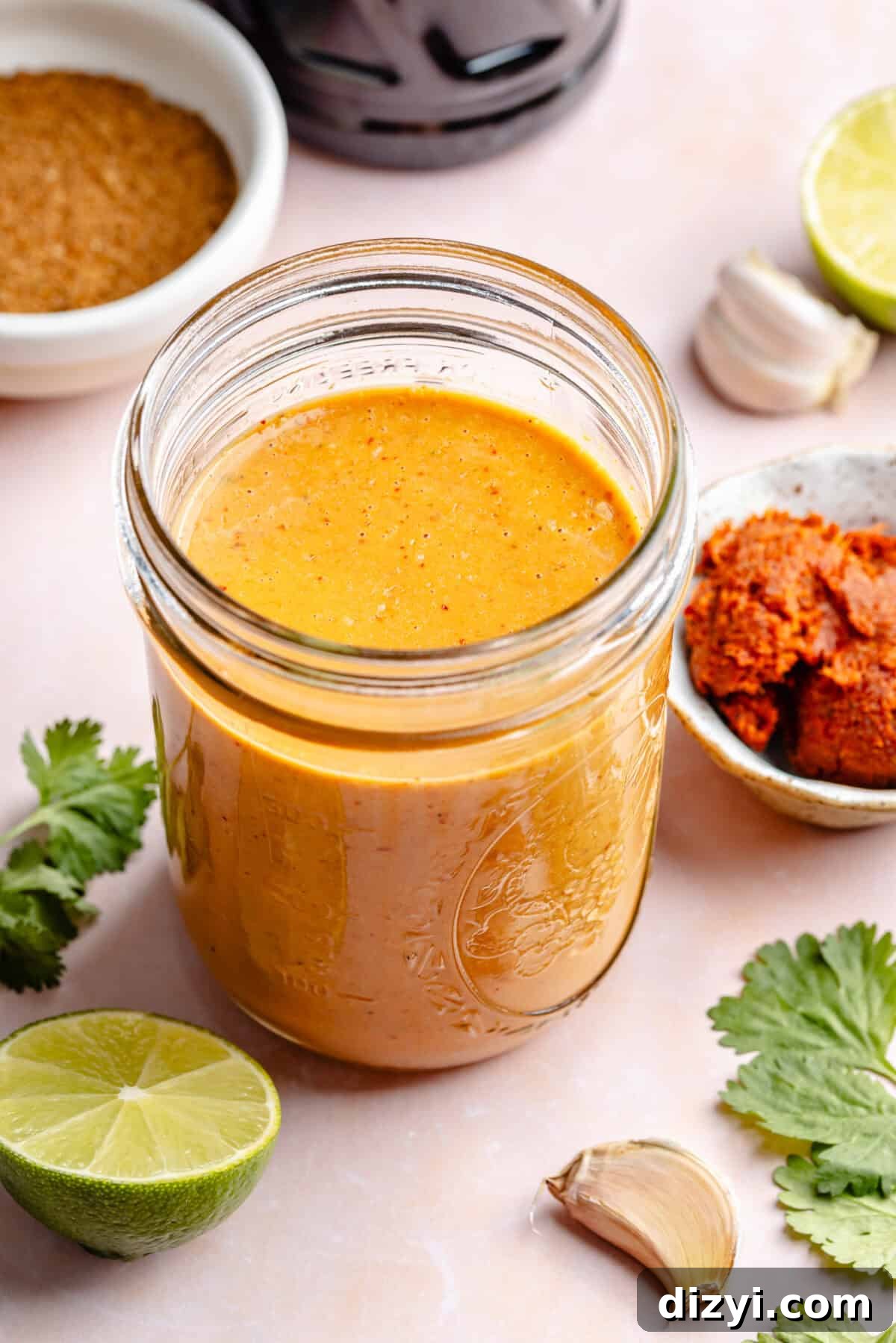 Curry sauce in glass jar with other ingredients around it.