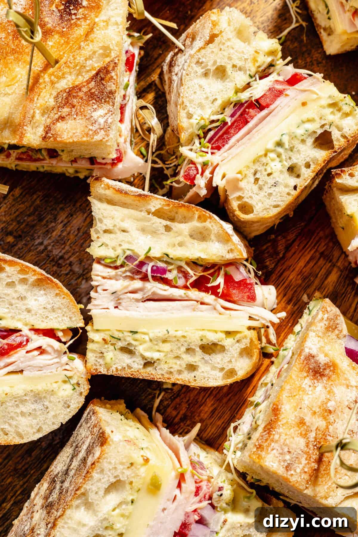 Turkey and Havarti Party Sandwiches with Dill-Pickle Mayo sliced on wooden cutting board.