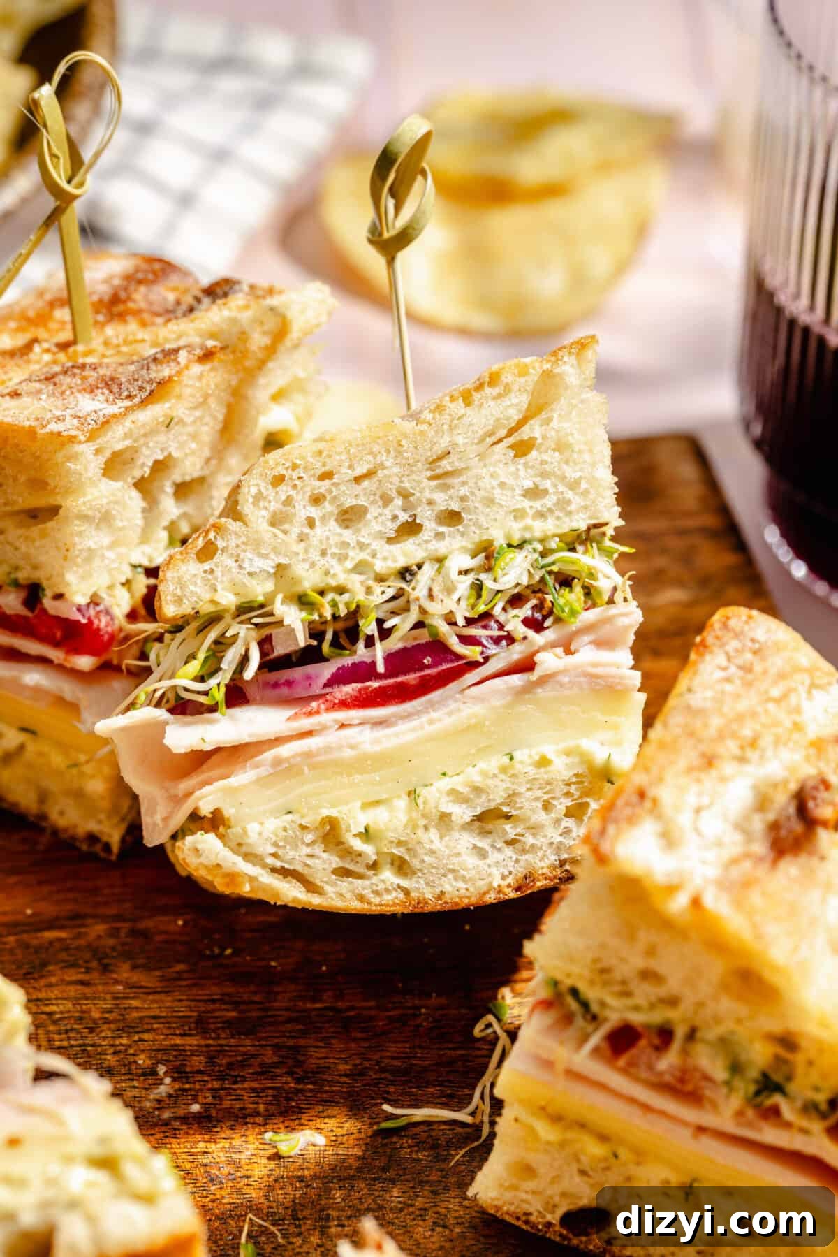 Turkey and Havarti Party Sandwiches with Dill-Pickle Mayo sliced and on wooden tray.