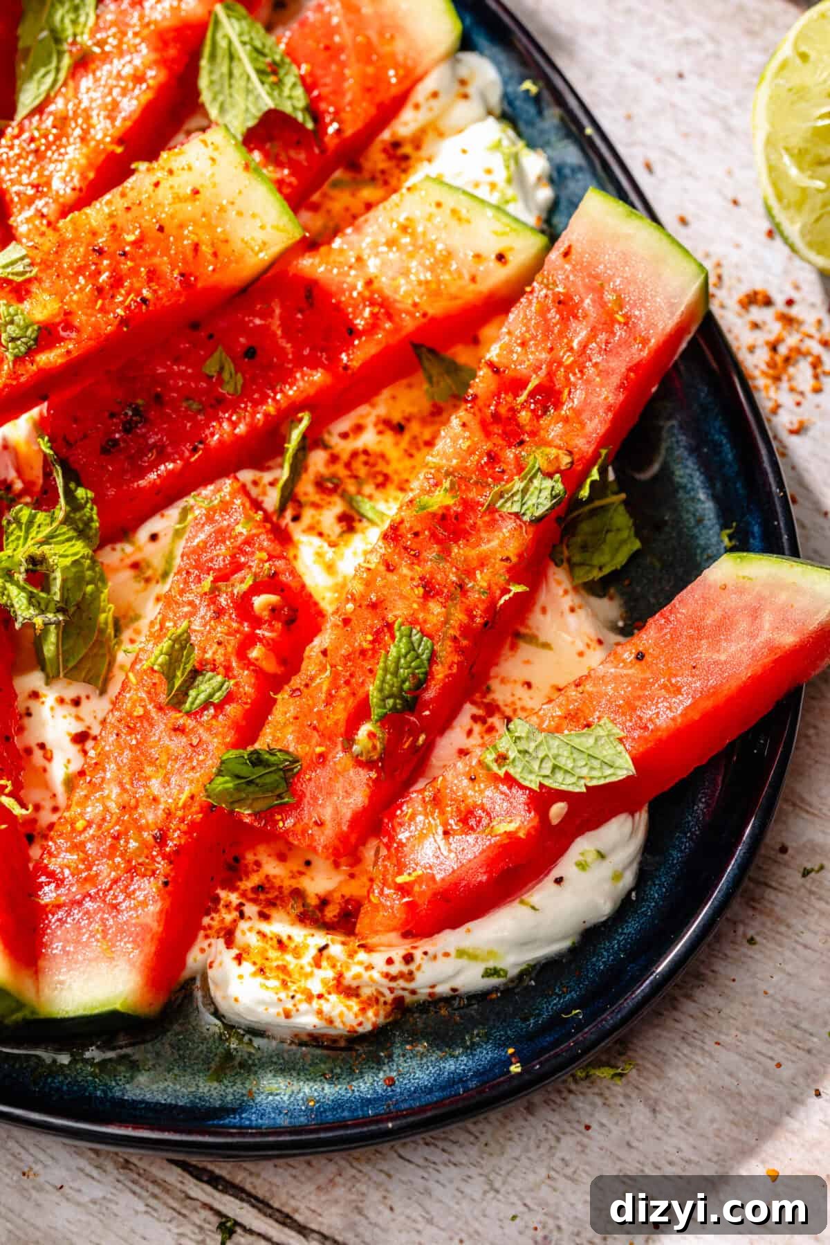 Chili-Lime Watermelon Salad with Labneh and Hot Honey Recipe 3 Chili Lime Watermelon with Labneh and Hot Honey on blue platter.
