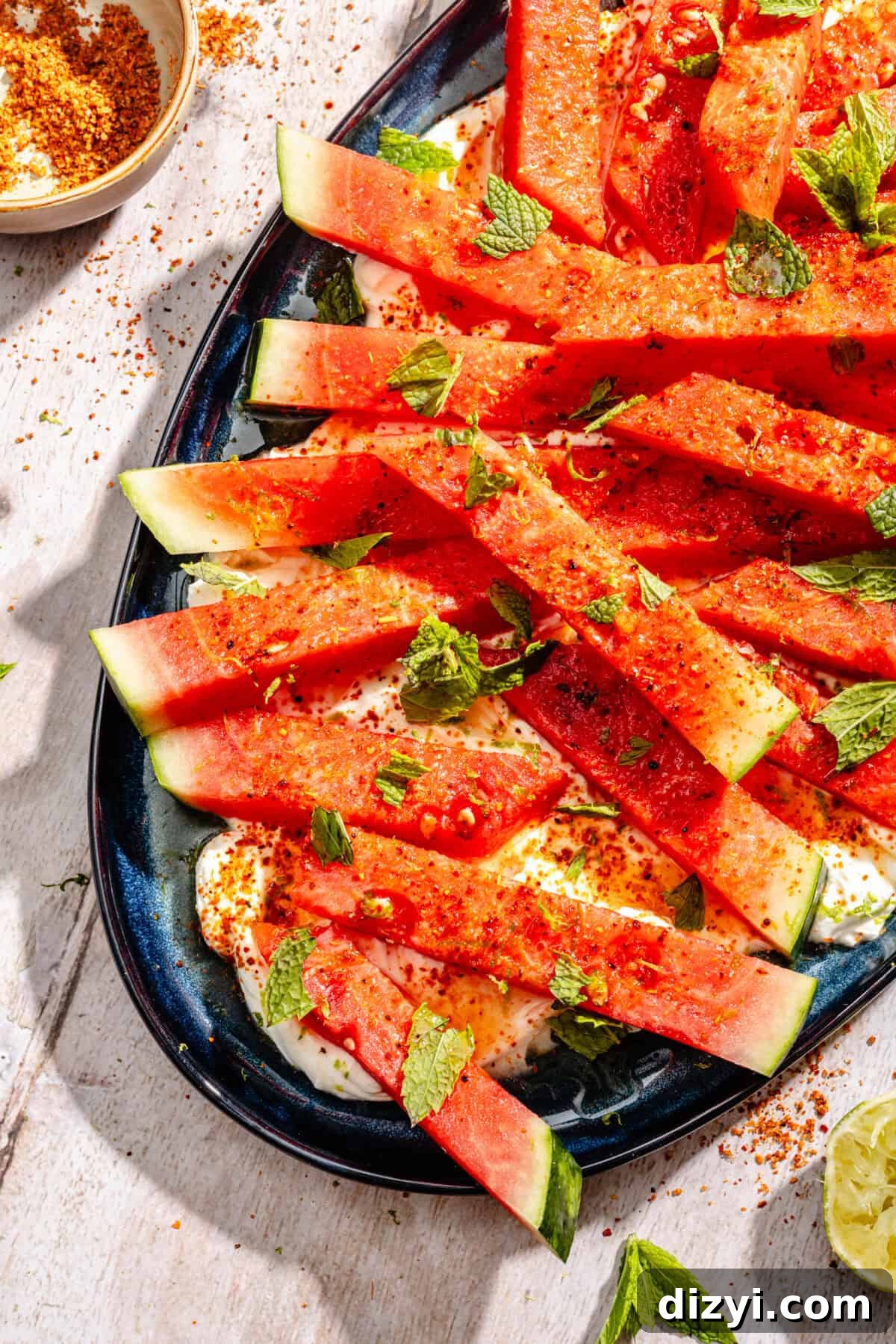 Chili-Lime Watermelon Salad with Labneh and Hot Honey Recipe 6 Chili Lime Watermelon with Labneh and Hot Honey on blue platter.